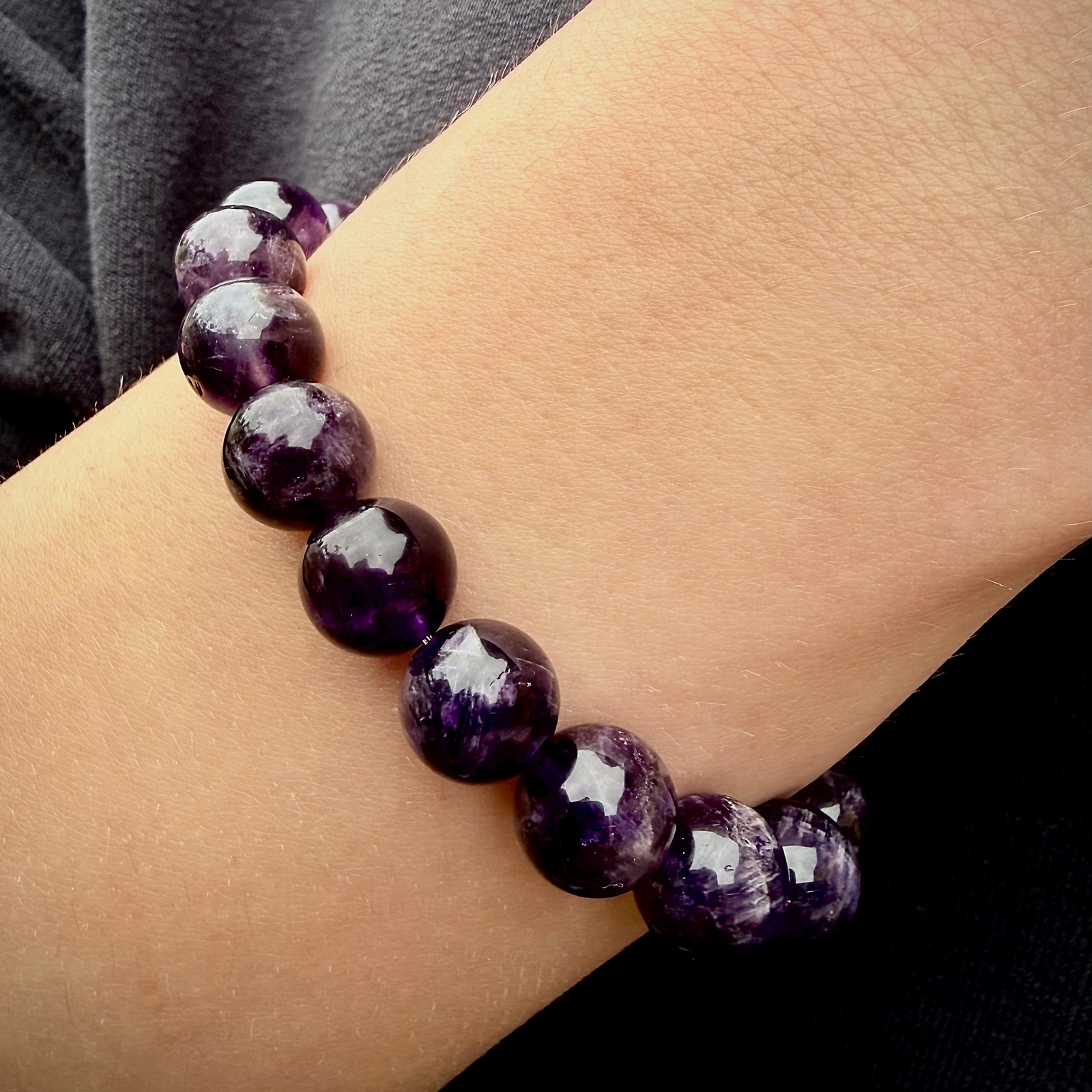 Purple beaded bracelet on a wrist with a blurred background