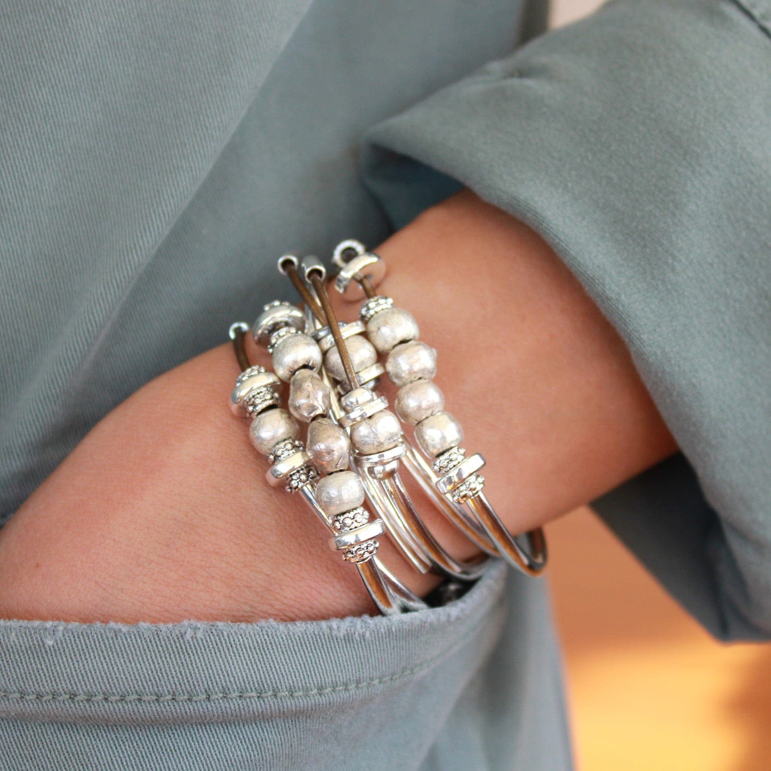 Person wearing the Bella Metallic Bronze Leather Wrap Bracelet with Silver & Mixed Metal Beads