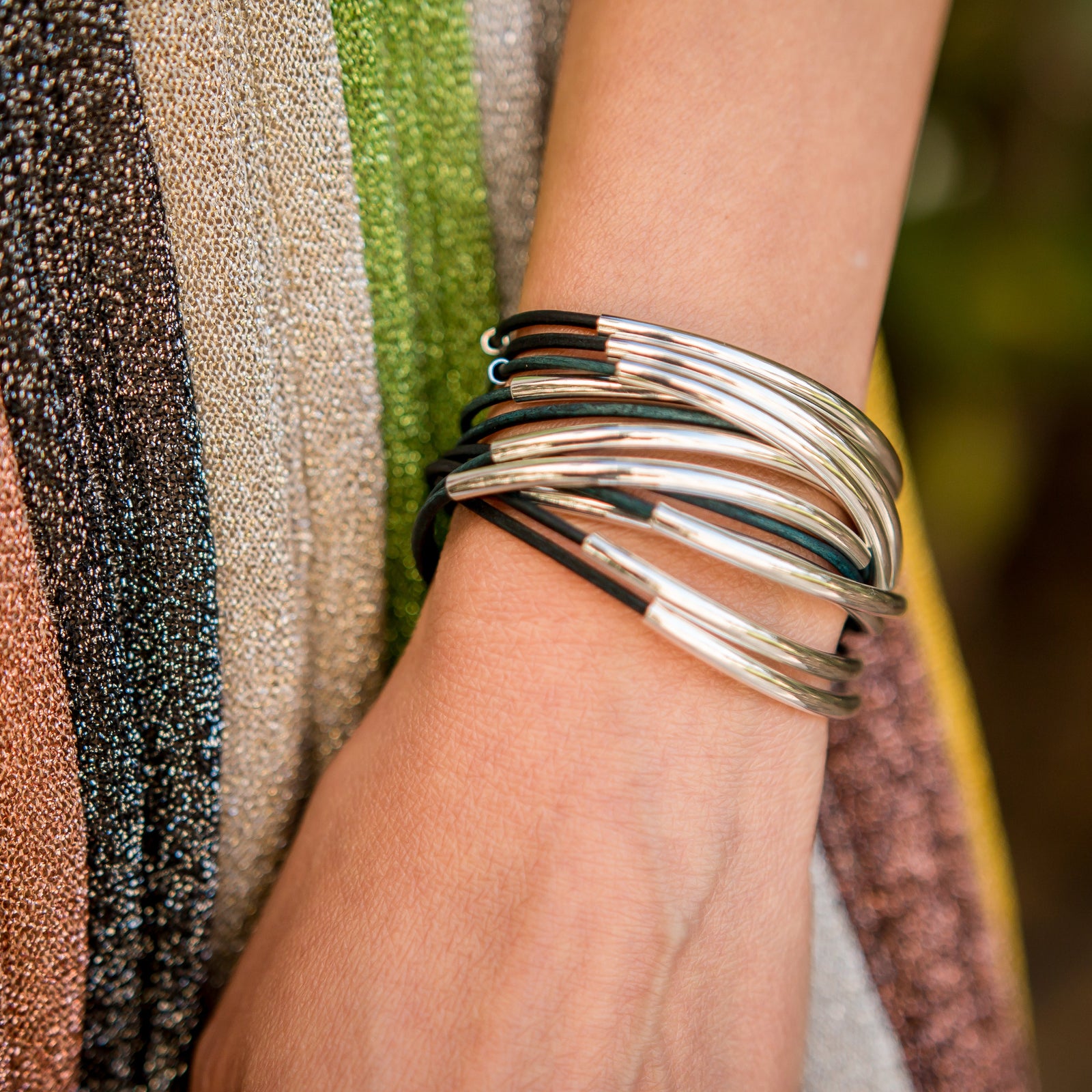 Close-up of Lizzy Classic Natural Peacock leather bracelet showing blue-green leather texture and silver-plated crescents.