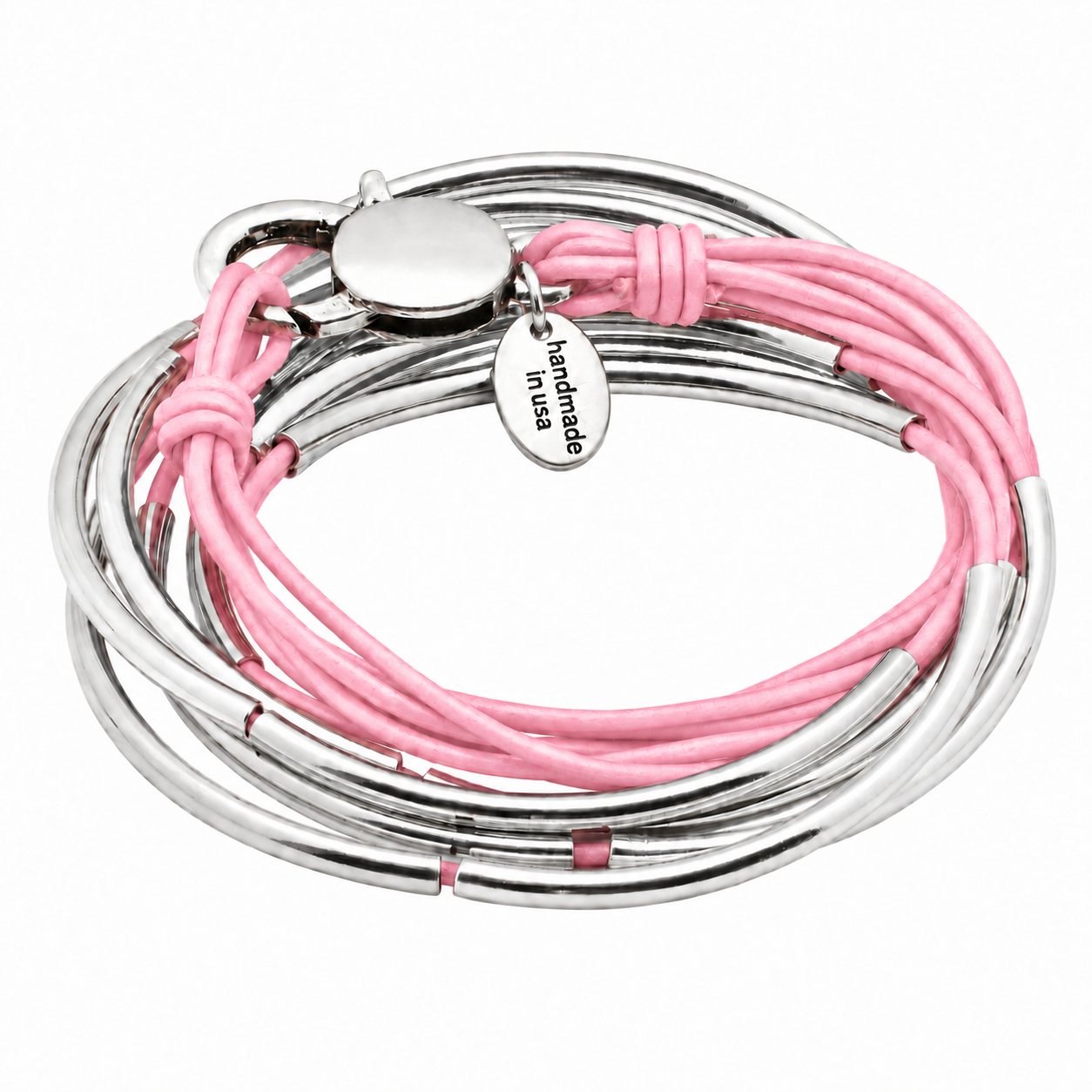 A close-up of a person's wrist wearing a stack of multi-layered bangles, featuring light pink cords and polished silver metal tubes, paired with a blue denim sleeve.