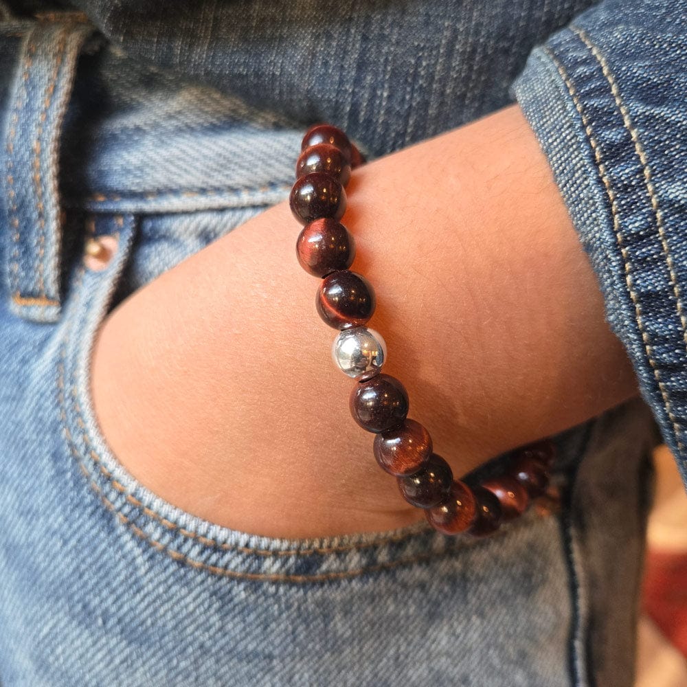 Close-up of a wrist wearing a beaded bracelet with a blurred background