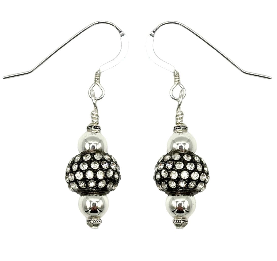 Close-up of a person wearing a silver earring with a bead detail.
