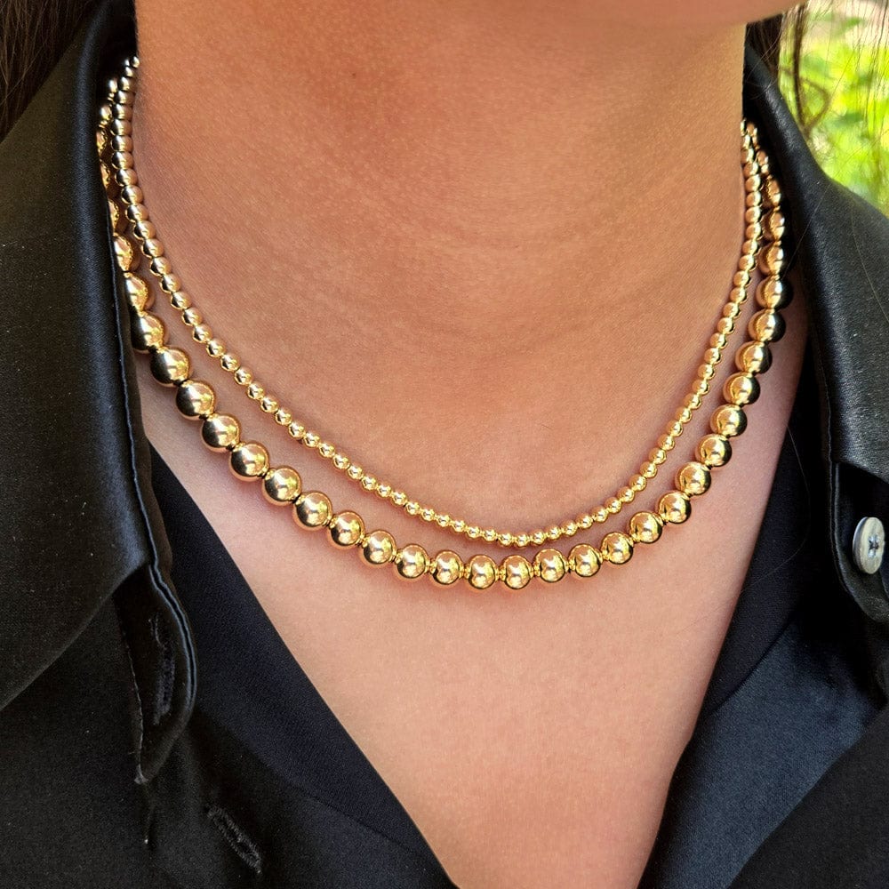 Gold necklaces layered for a chic look featuring 14k gold-filled round and rice shaped beads