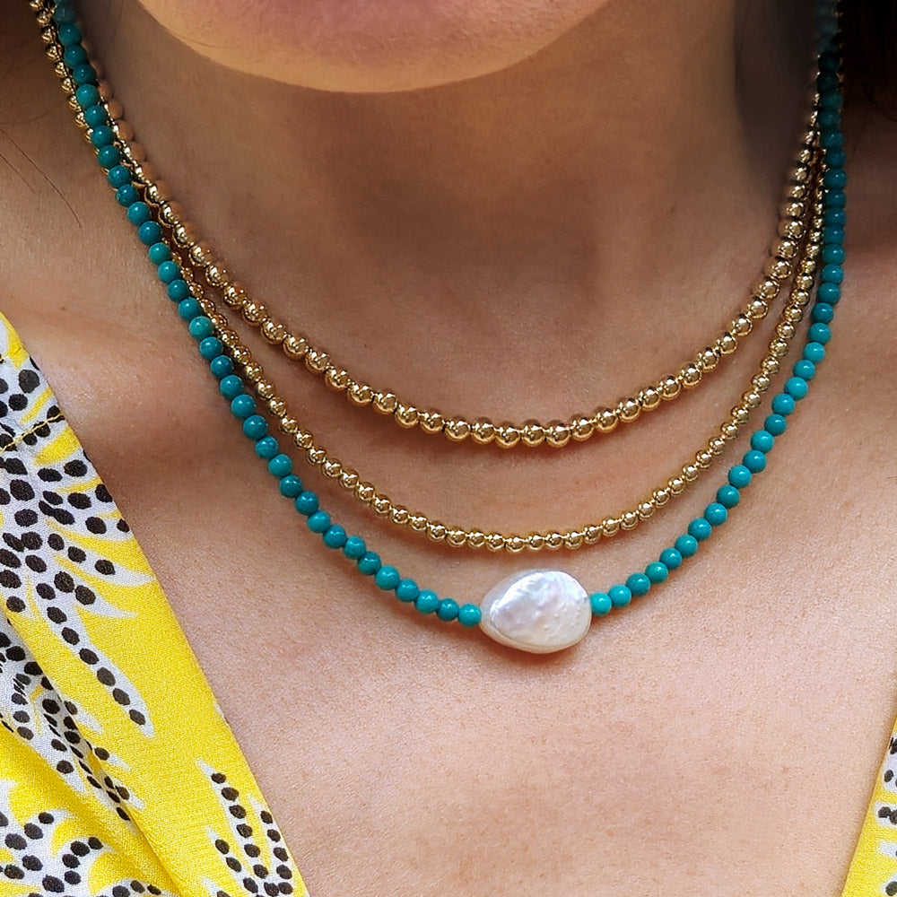 Beaded necklaces shown in 14k gold filled and turquoise beads with large freshwater pearl