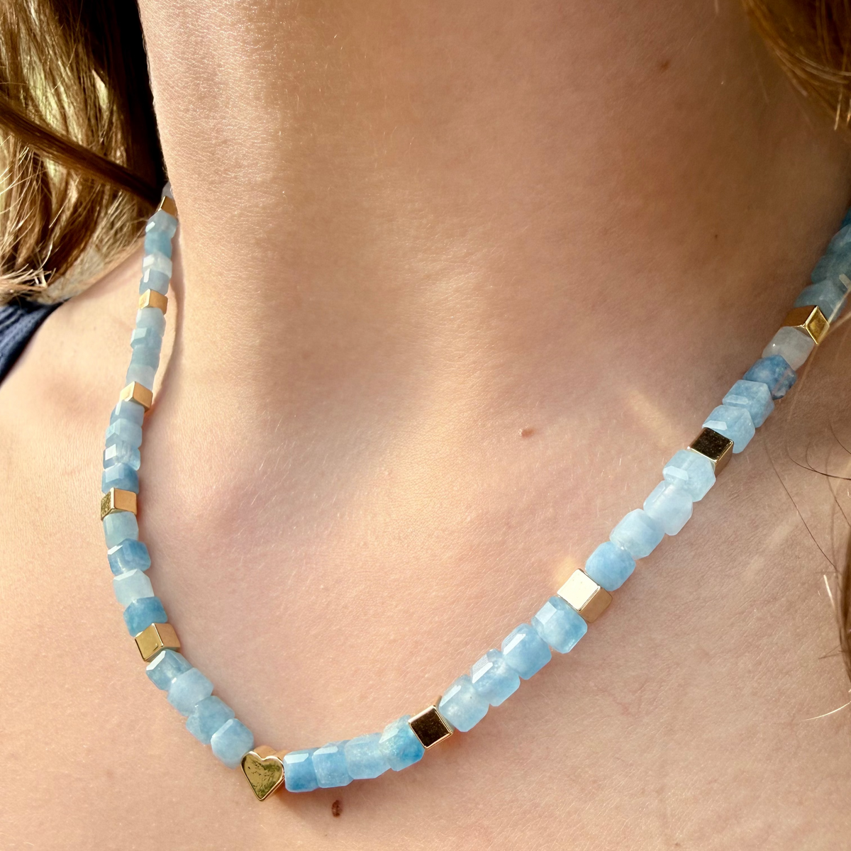 Aquamarine 16 inch necklace worn at collarbone with gold heart focal and faceted gemstone cubes