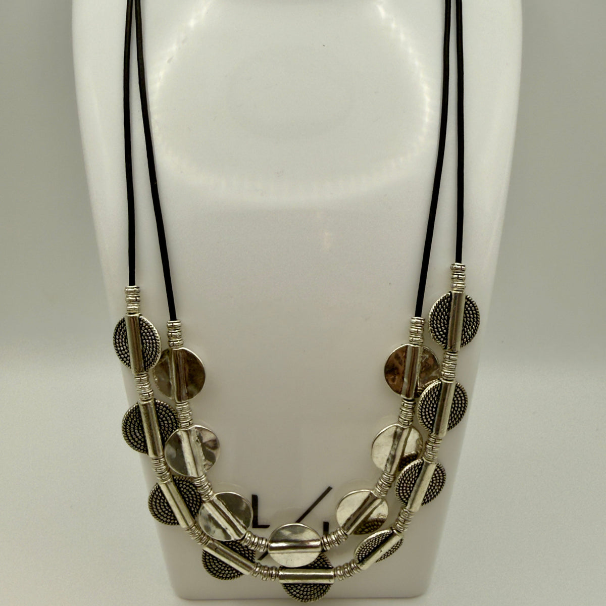 Vesper black leather 2-tier The Vesper Layers 2-tier black leather necklace with silver-plate textured disks and round beads.