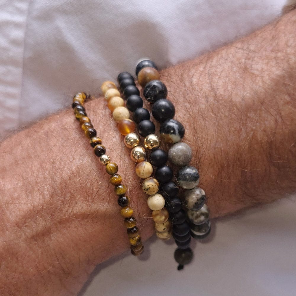 Two stacked men&#39;s black onyx beaded bracelets with agate and tiger&#39;s eye, featuring 14k gold beads