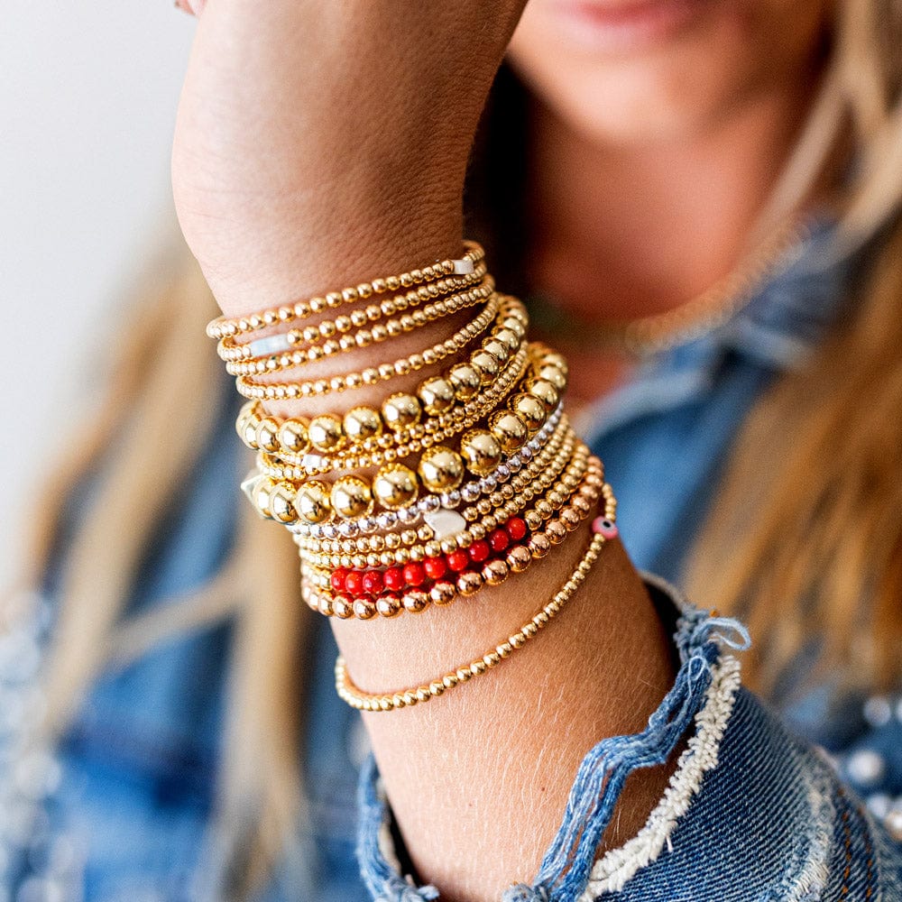 3mm 14k gold-filled beaded bracelet stack with 4mm and 6mm 14k gold-filled bracelets featuring coral beads and a sterling silver beaded bracelet