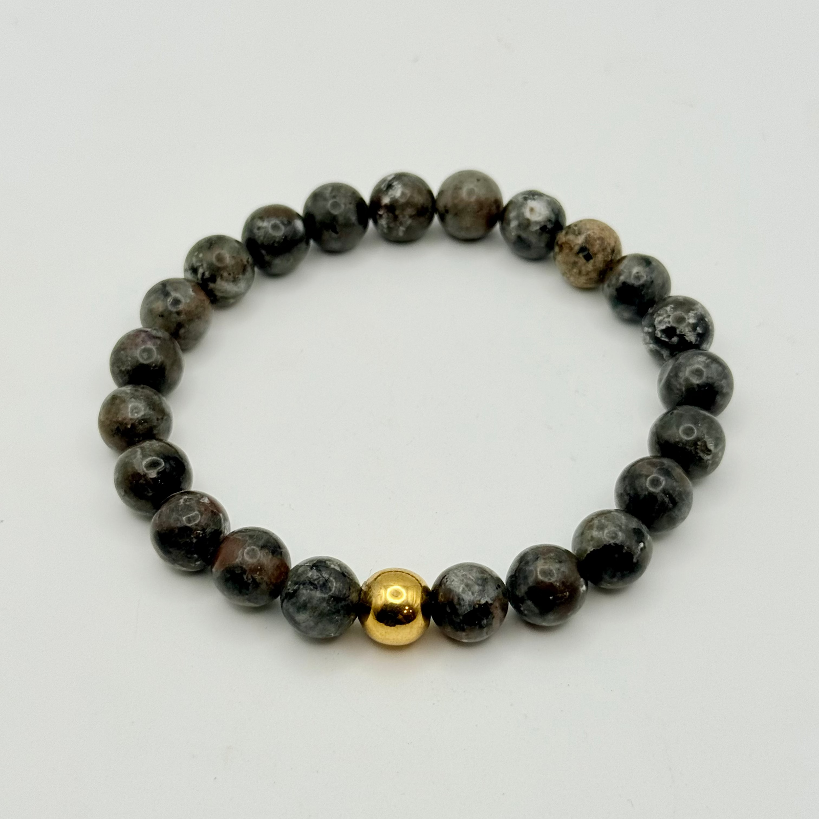 Close-up of a wrist wearing a beaded bracelet with a gold accent.