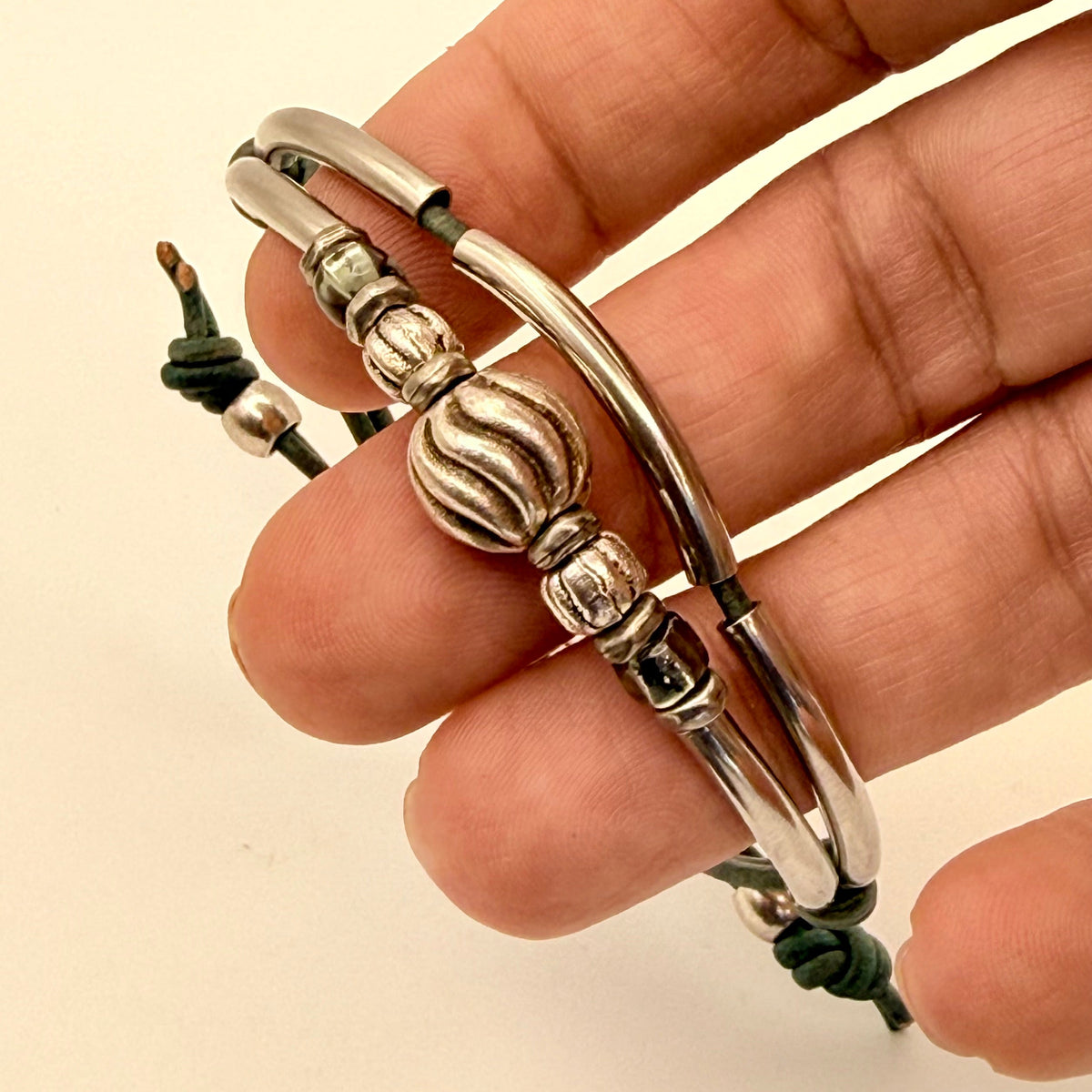 Silver bracelet with decorative elements on a beige background