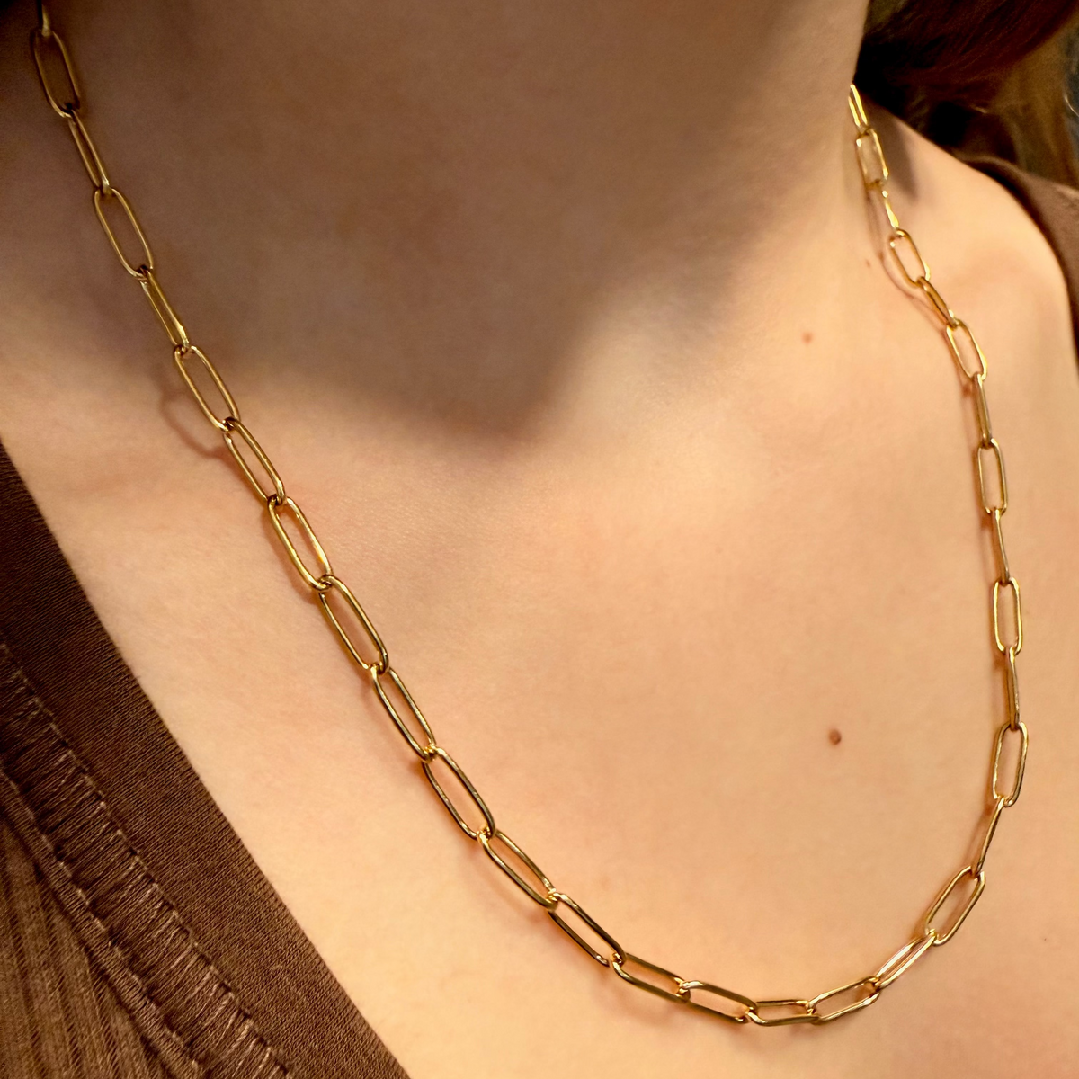 Gold chain necklace worn by a person