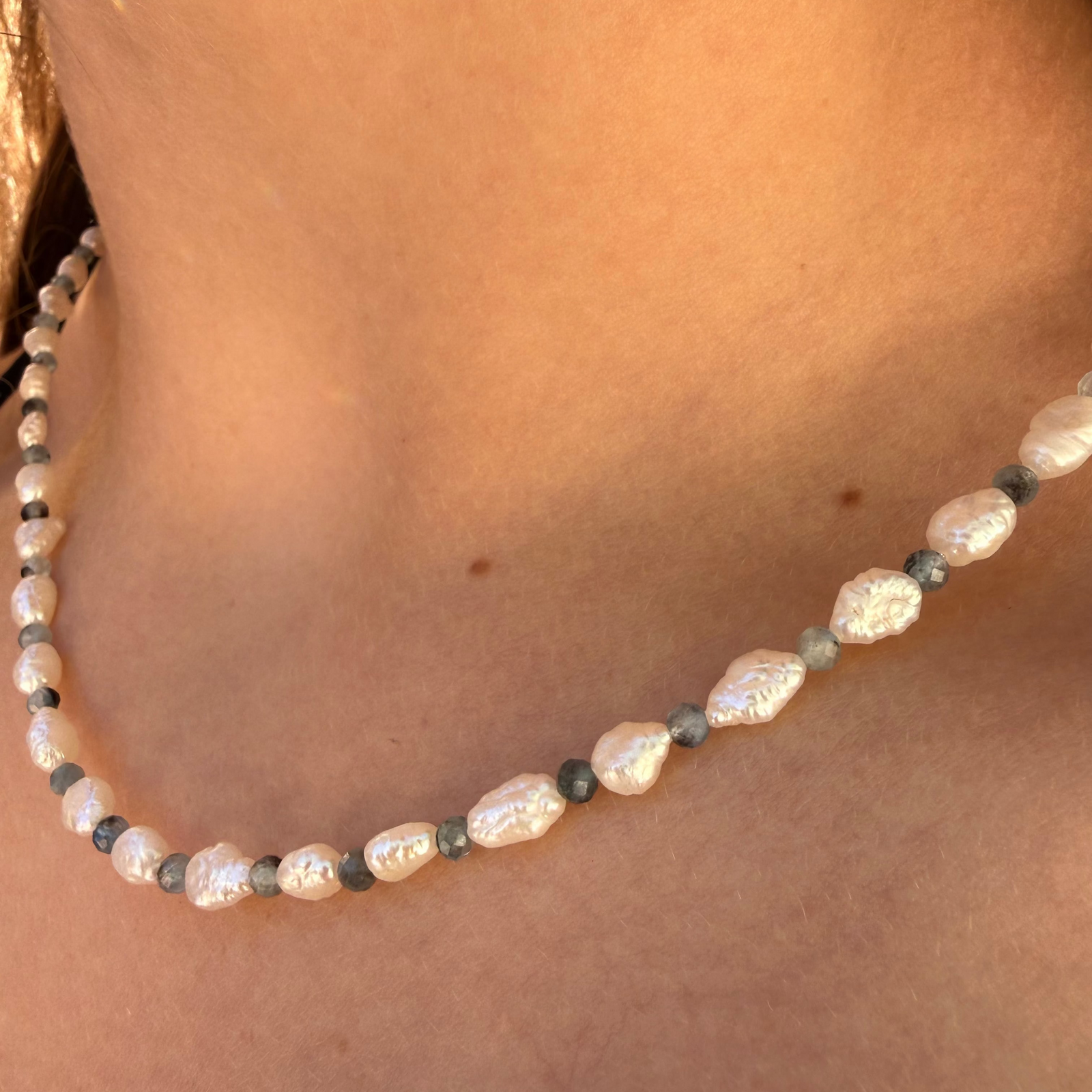 Close-up of a pearl necklace on a person's neck
