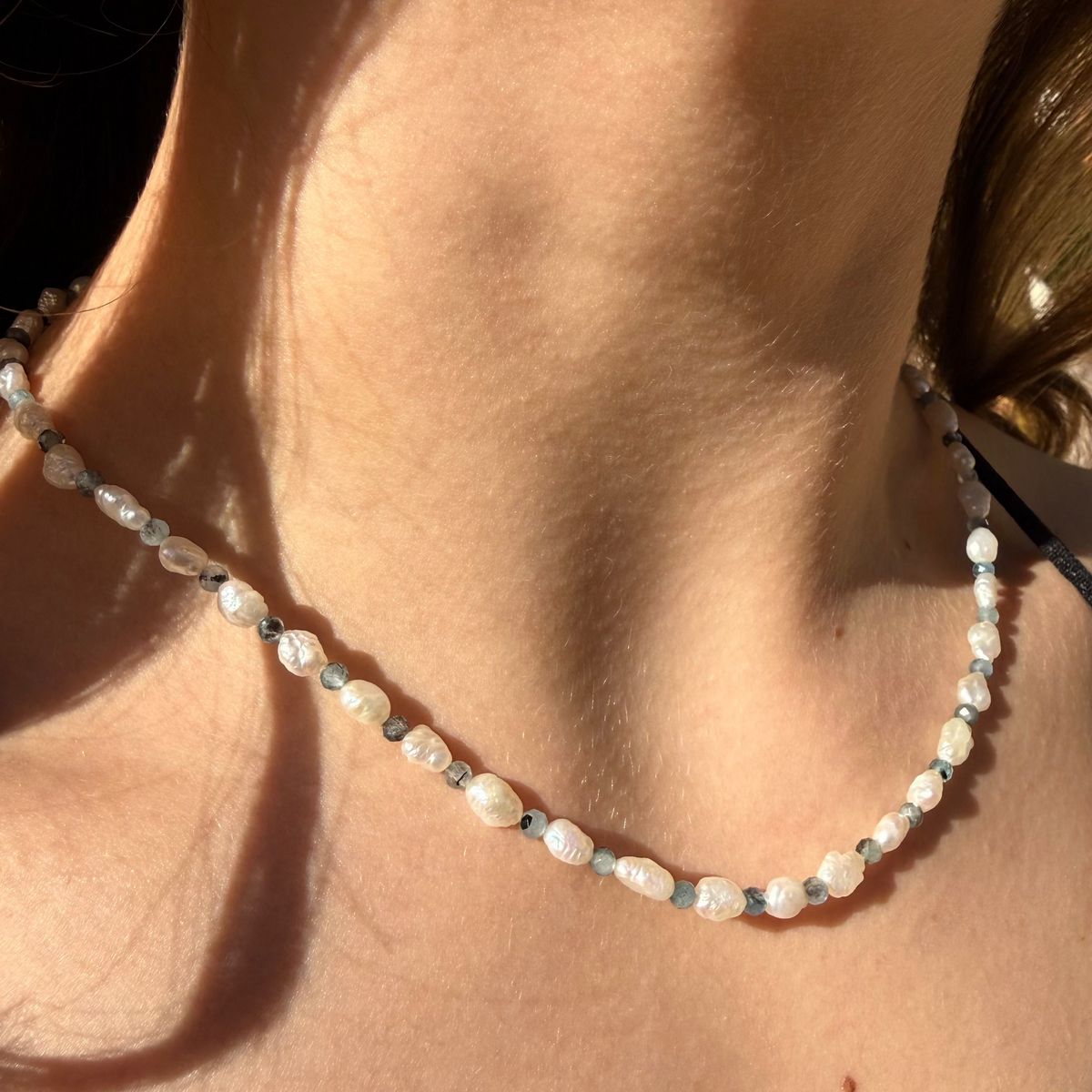 Close-up of a pearl necklace on a person's neck