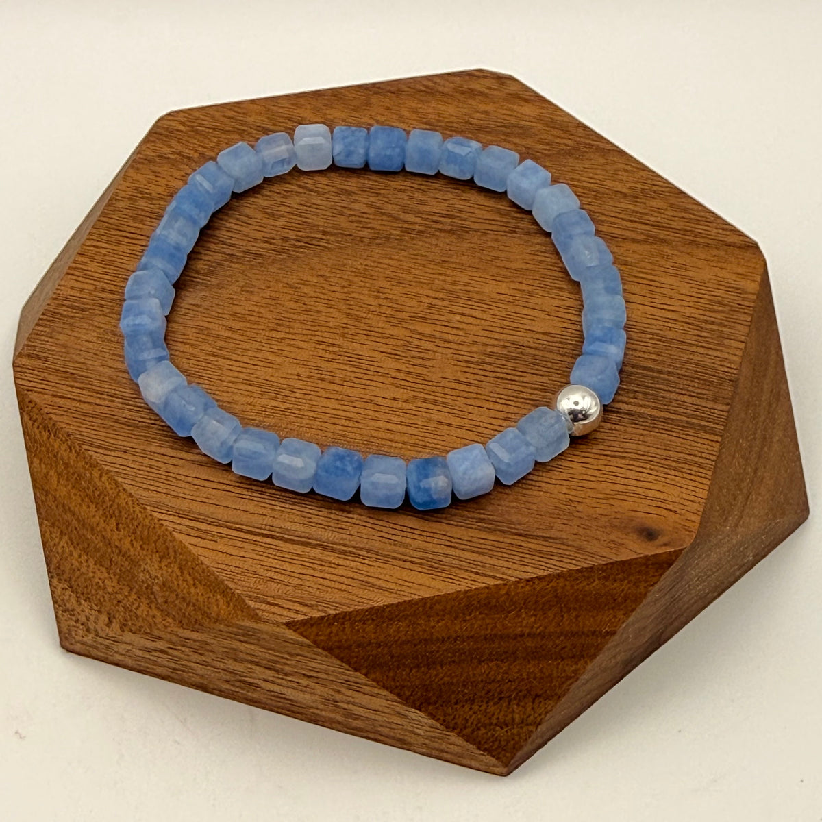 5mm faceted Aquamarine cube bracelet with sterling silver accent on wooden platform – March birthstone stretch bracelet handmade in California