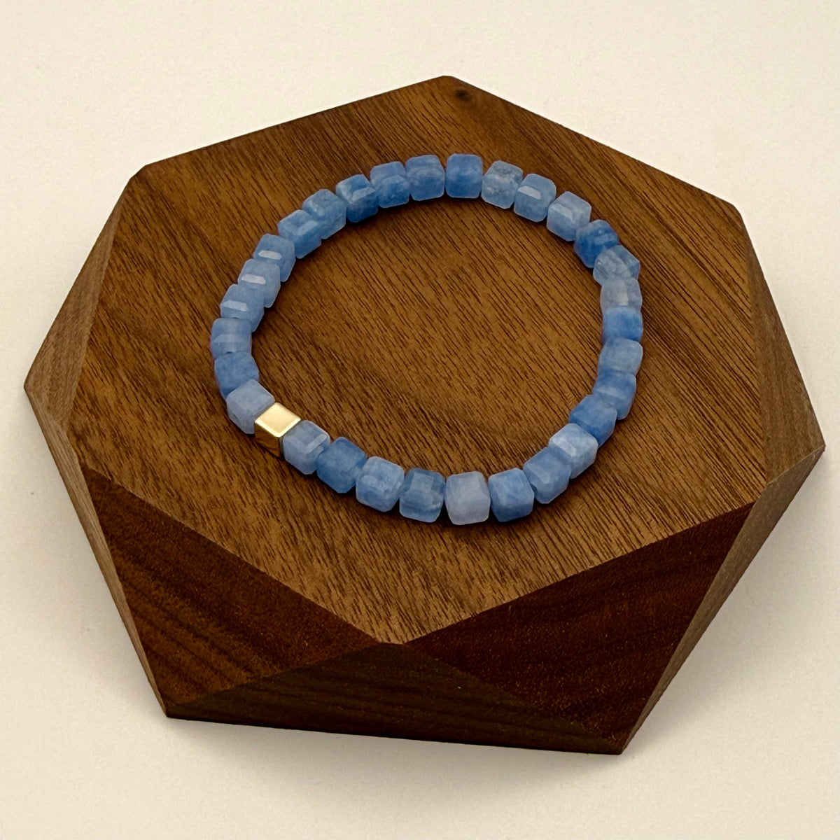 Blue beaded bracelet on a wooden hexagonal stand