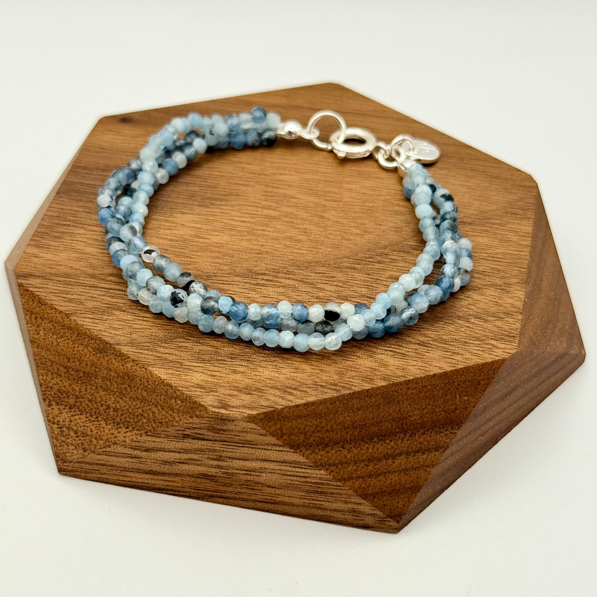 Stack of blue beaded bracelets on a wooden hexagonal block