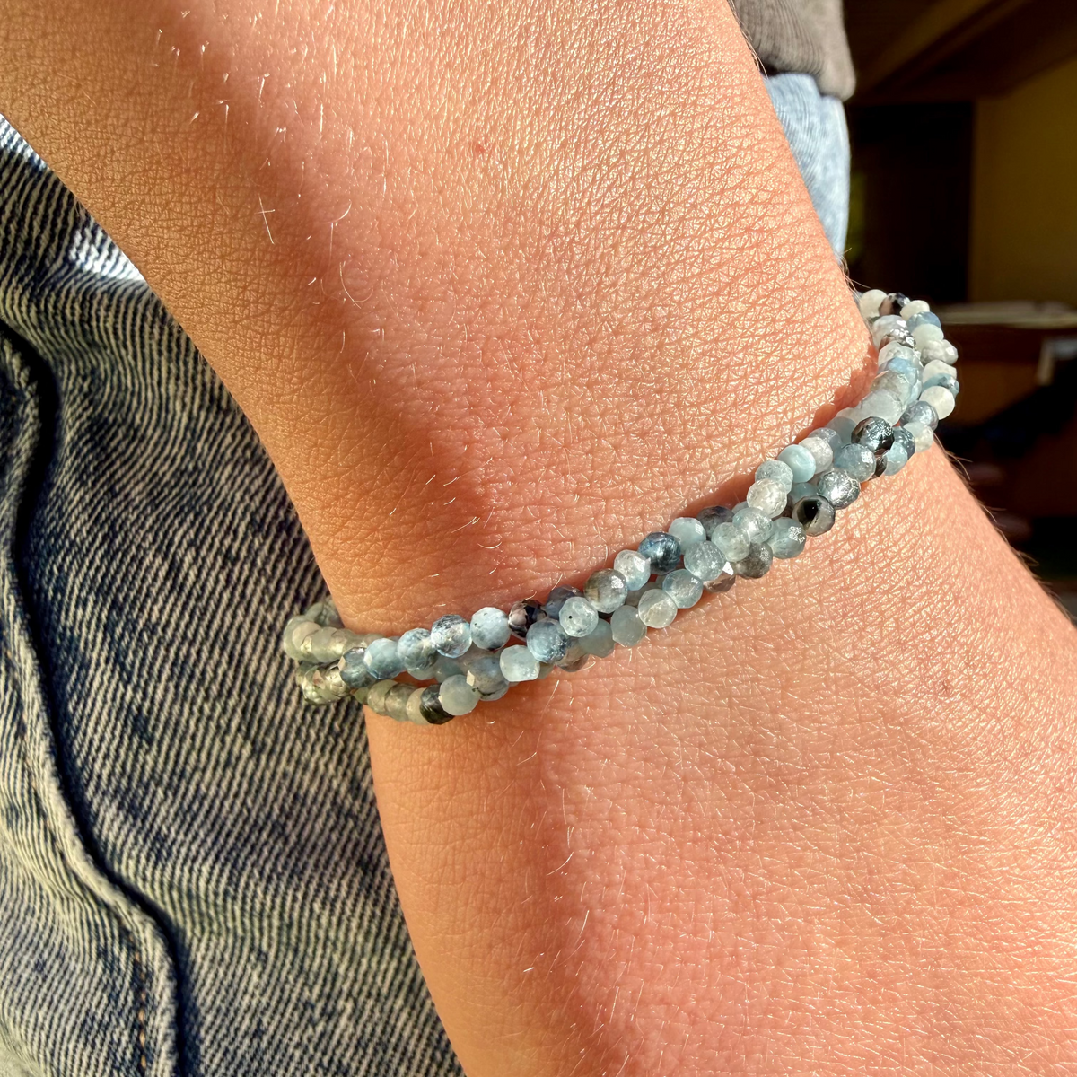 Close-up of a wrist wearing a beaded bracelet with a blurred background