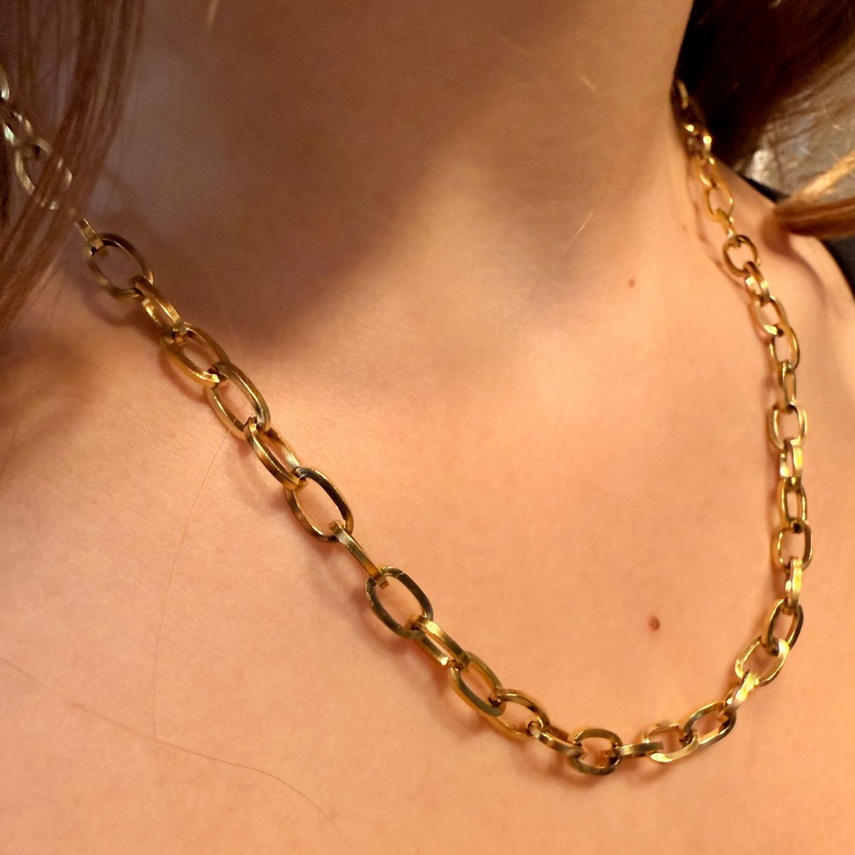 Gold chain necklace on a person's neck