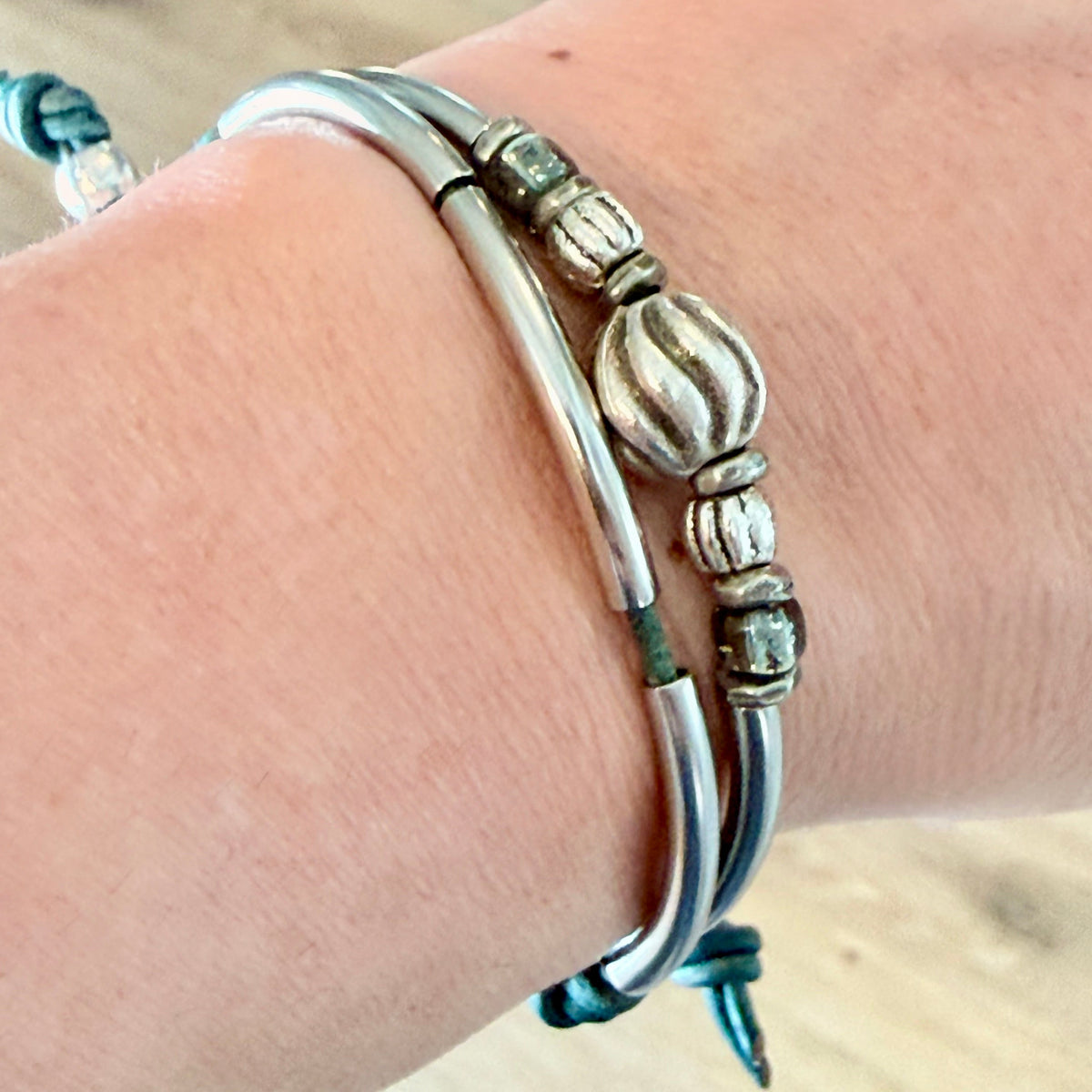 Silver bracelet on a wrist with a wooden background