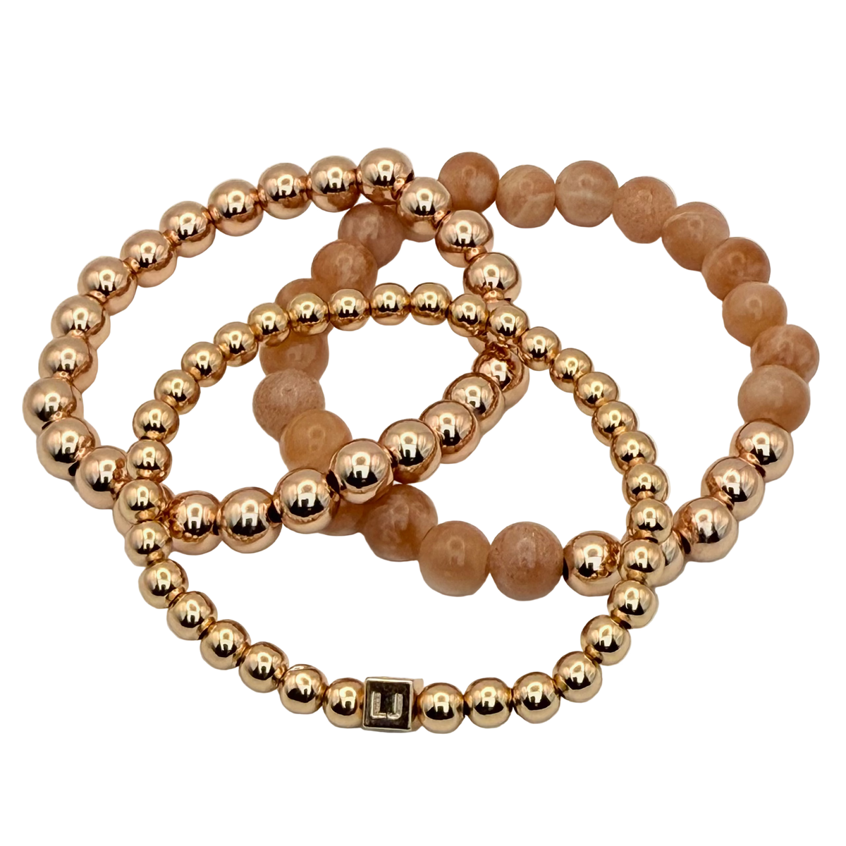 Two beaded bracelets, one gold and one brown, on a white background.