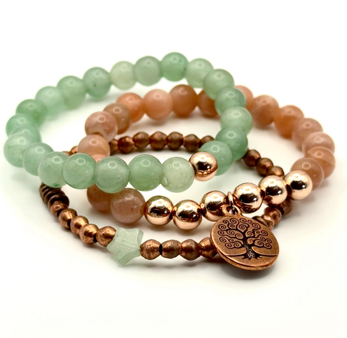Set of beaded bracelets with a tree of life charm on a white background