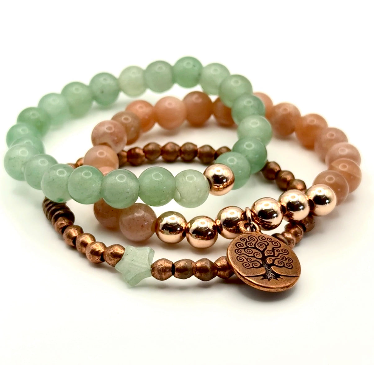 Set of beaded bracelets with a tree of life charm on a white background