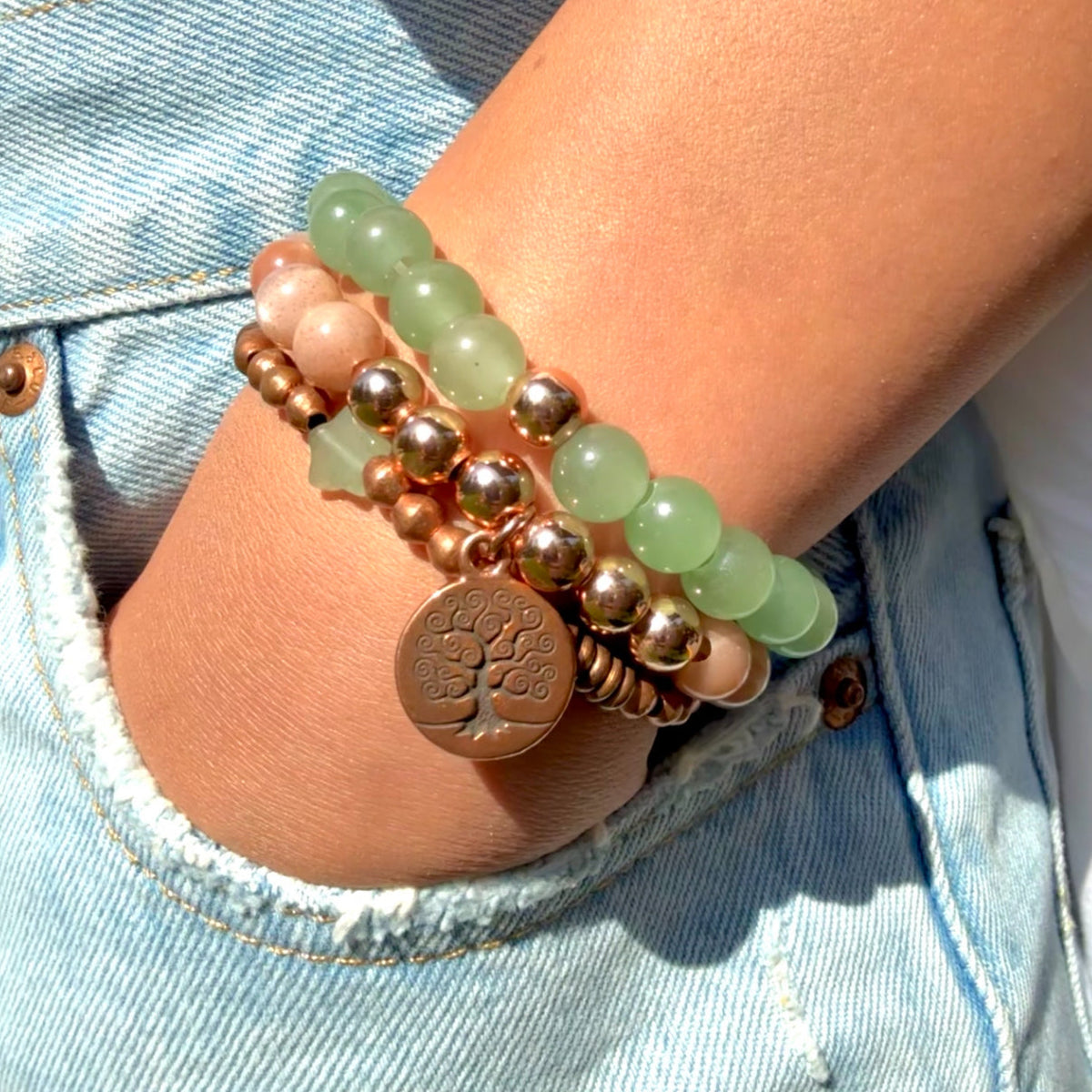 Stack of beaded bracelets on a wrist with a denim background