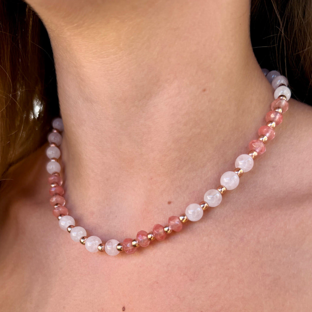 Woman wearing the Celia pink gemstone necklace with cherry quartz, rose quartz and rose gold-plated beads