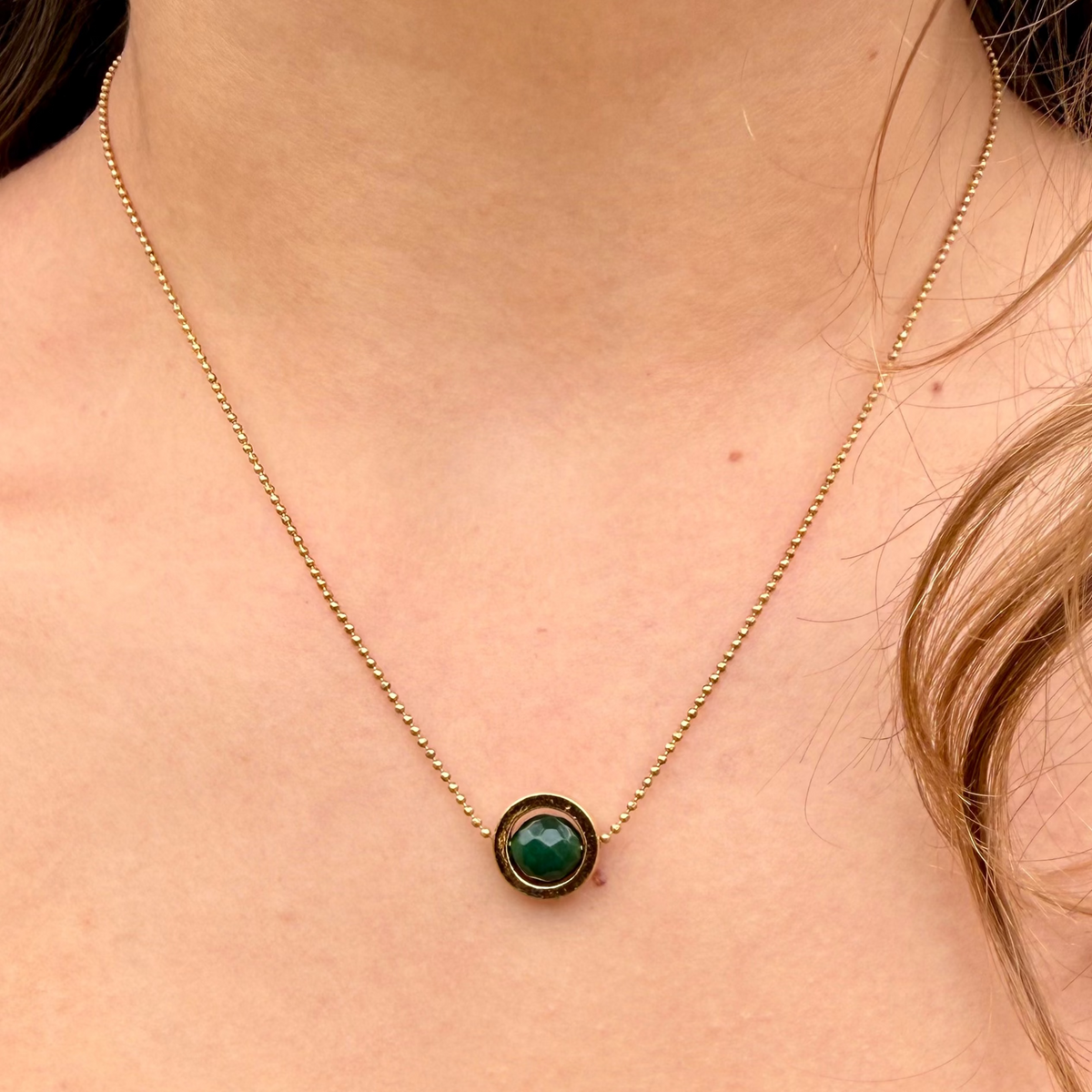 Woman wearing minimal emerald jade necklace with fine antique gold chain