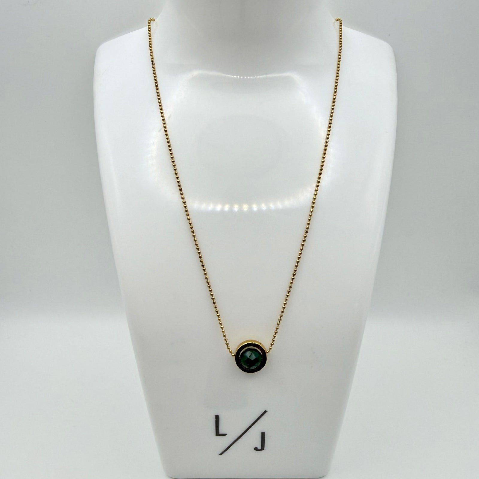 Woman wearing minimal emerald jade necklace with fine antique gold chain