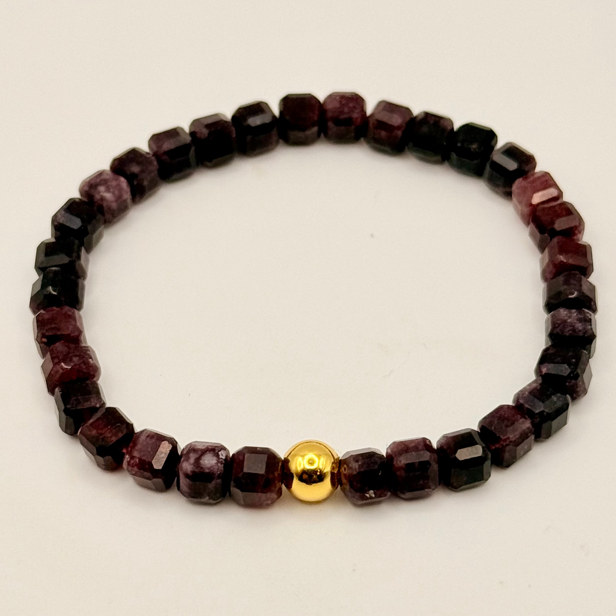Beaded bracelet with a gold accent on a beige background