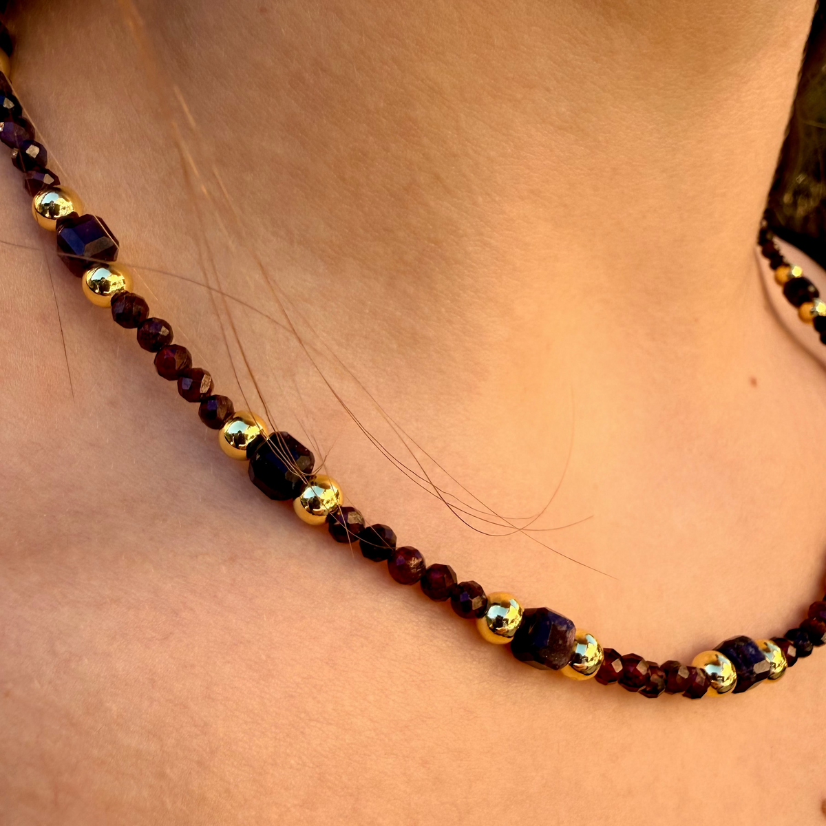 Necklace with brown and gold beads on a person's neck