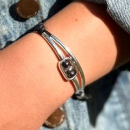 Silver bracelet on a wrist with a denim jacket background