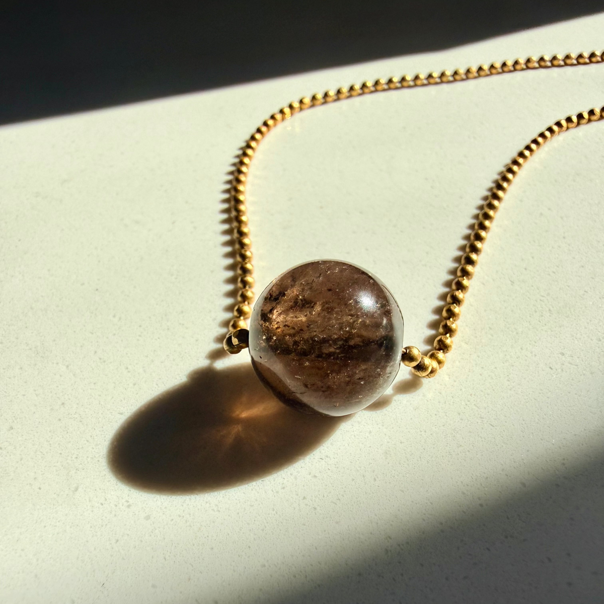 Necklace with a brown pendant on a light surface