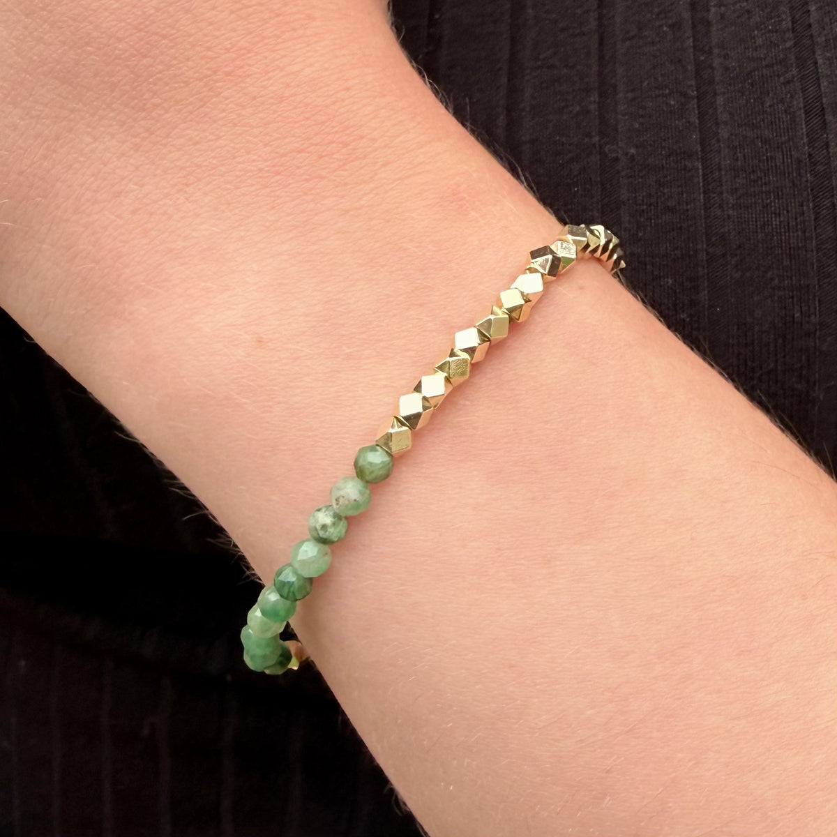 Woman wearing Elowen emerald bracelet with natural green gemstones and gold-filled beads