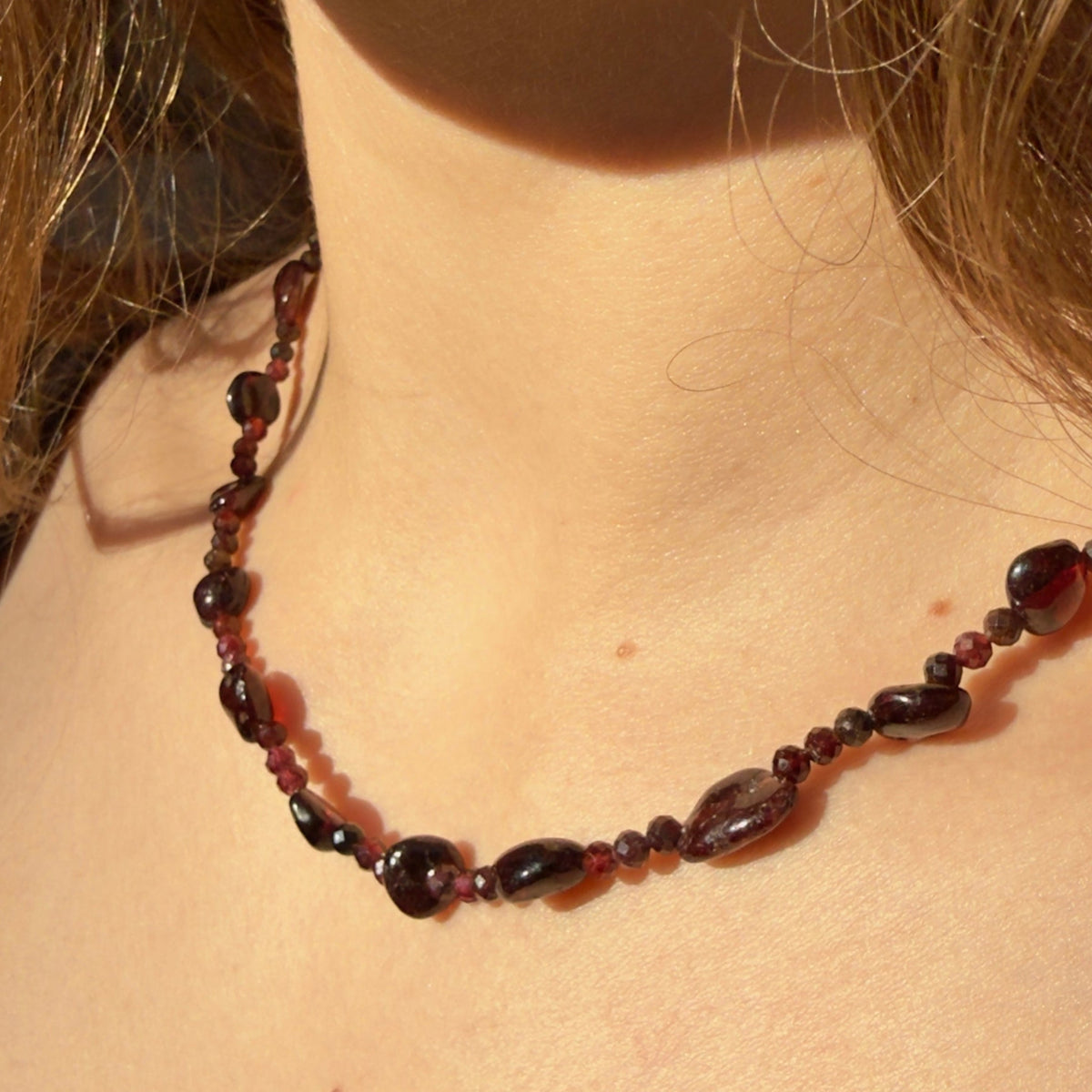 Garnet gemstone beaded necklace on a womens neck