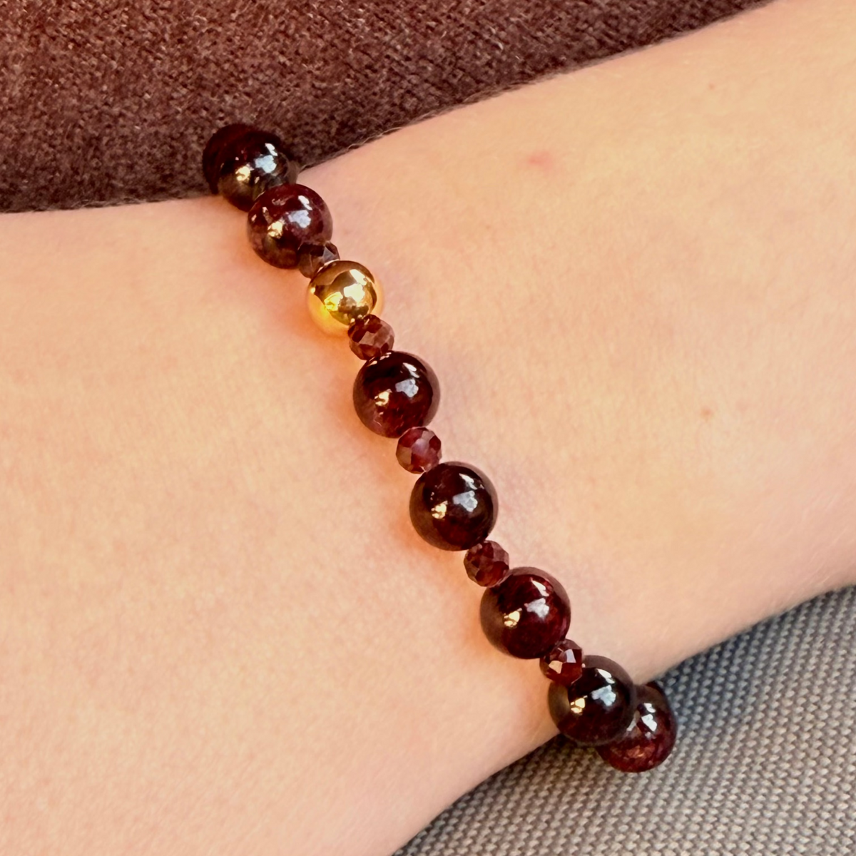 Beaded bracelet on a wrist with a brown background