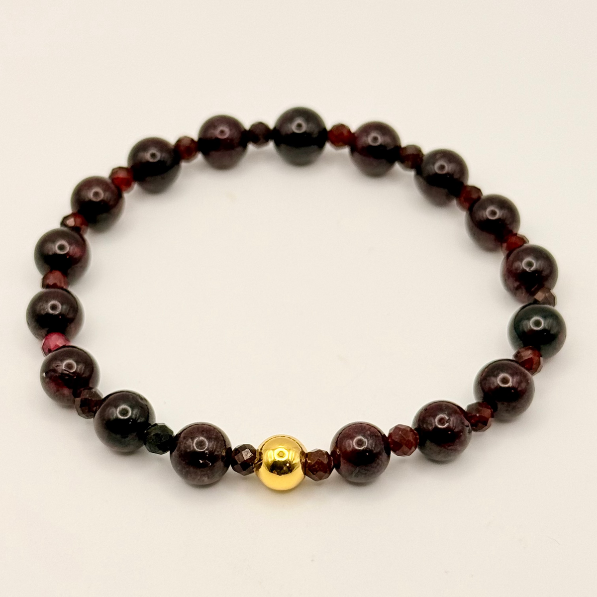 Black beaded bracelet with a gold accent on a white background
