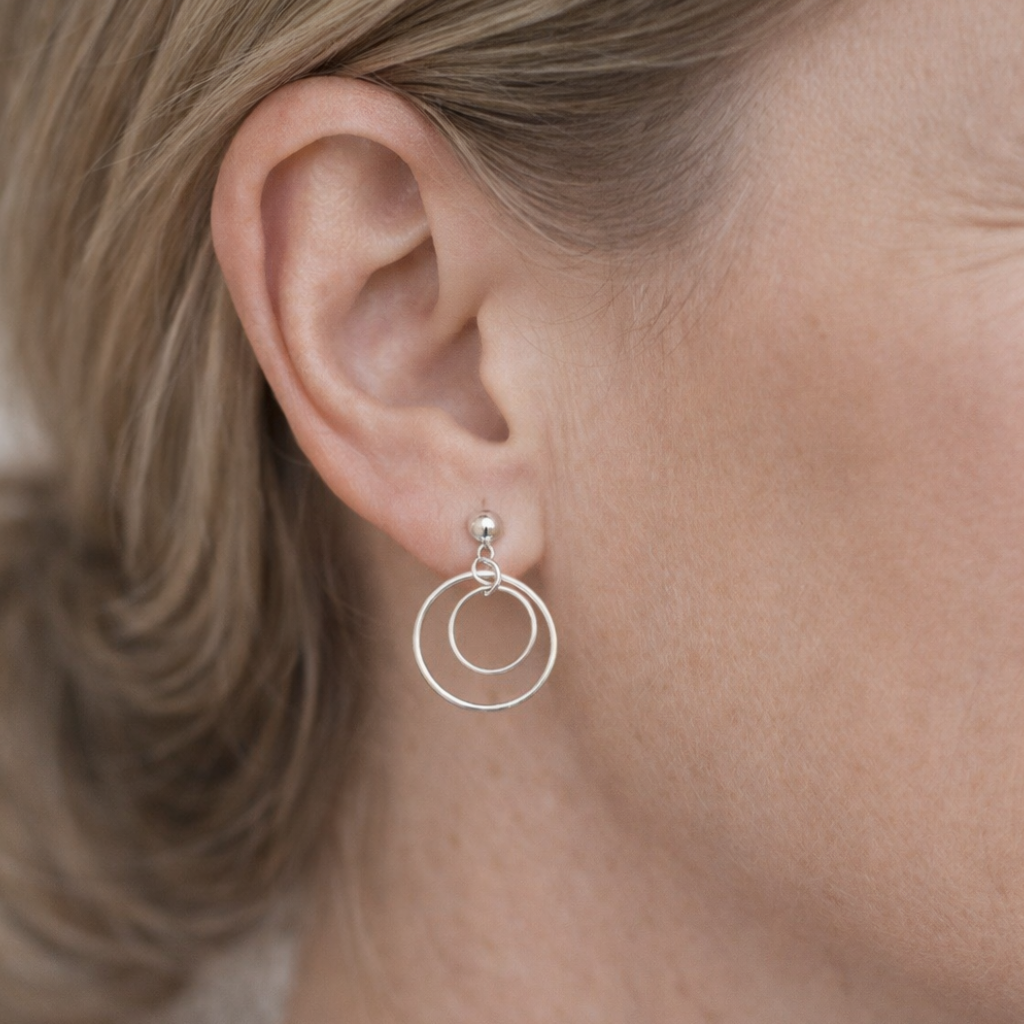 Close-up of a person wearing a silver hoop earring.