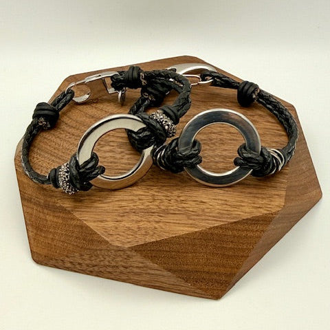 Bracelet with metal loops on a wooden stand against a beige background