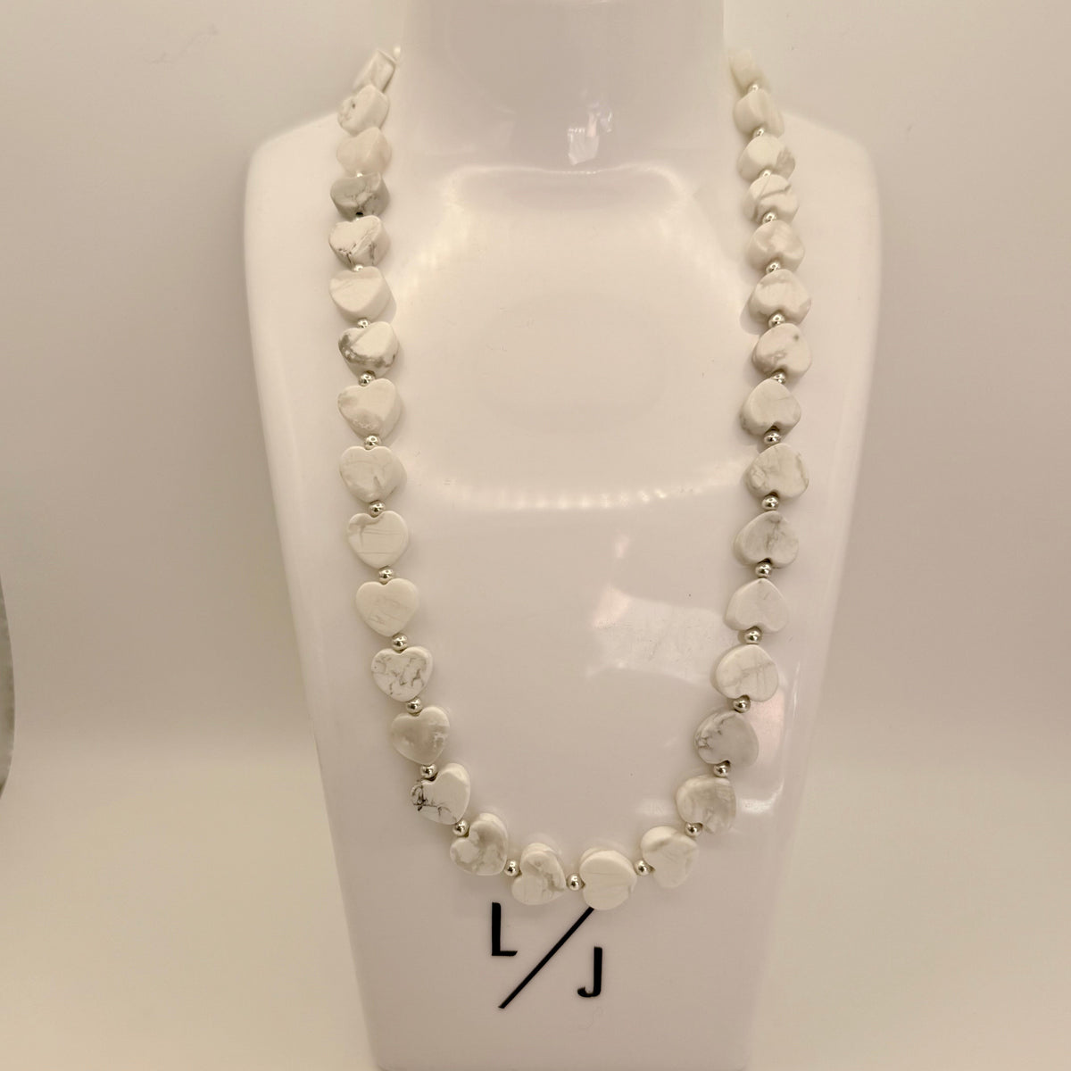 Howlite Heart Gemstone Necklace with Sterling Silver Beads around a womans neck