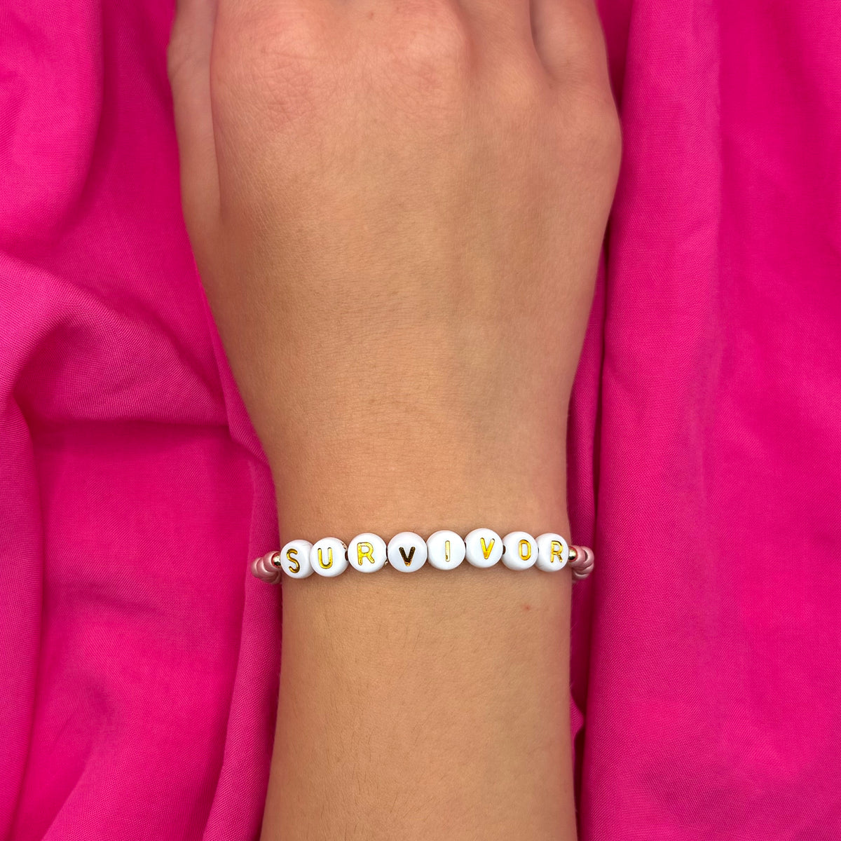 Survivor Stretch Bracelet with Pink Seed Beads, Gold Letters &amp; Accents