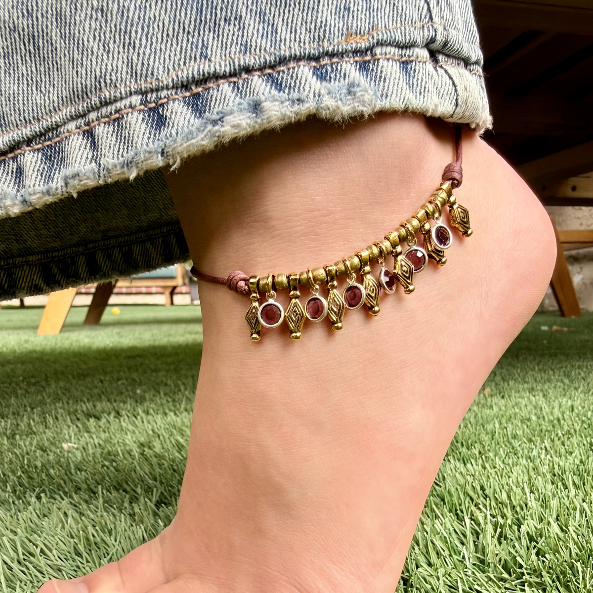Ankle bracelet on a foot against a grassy background