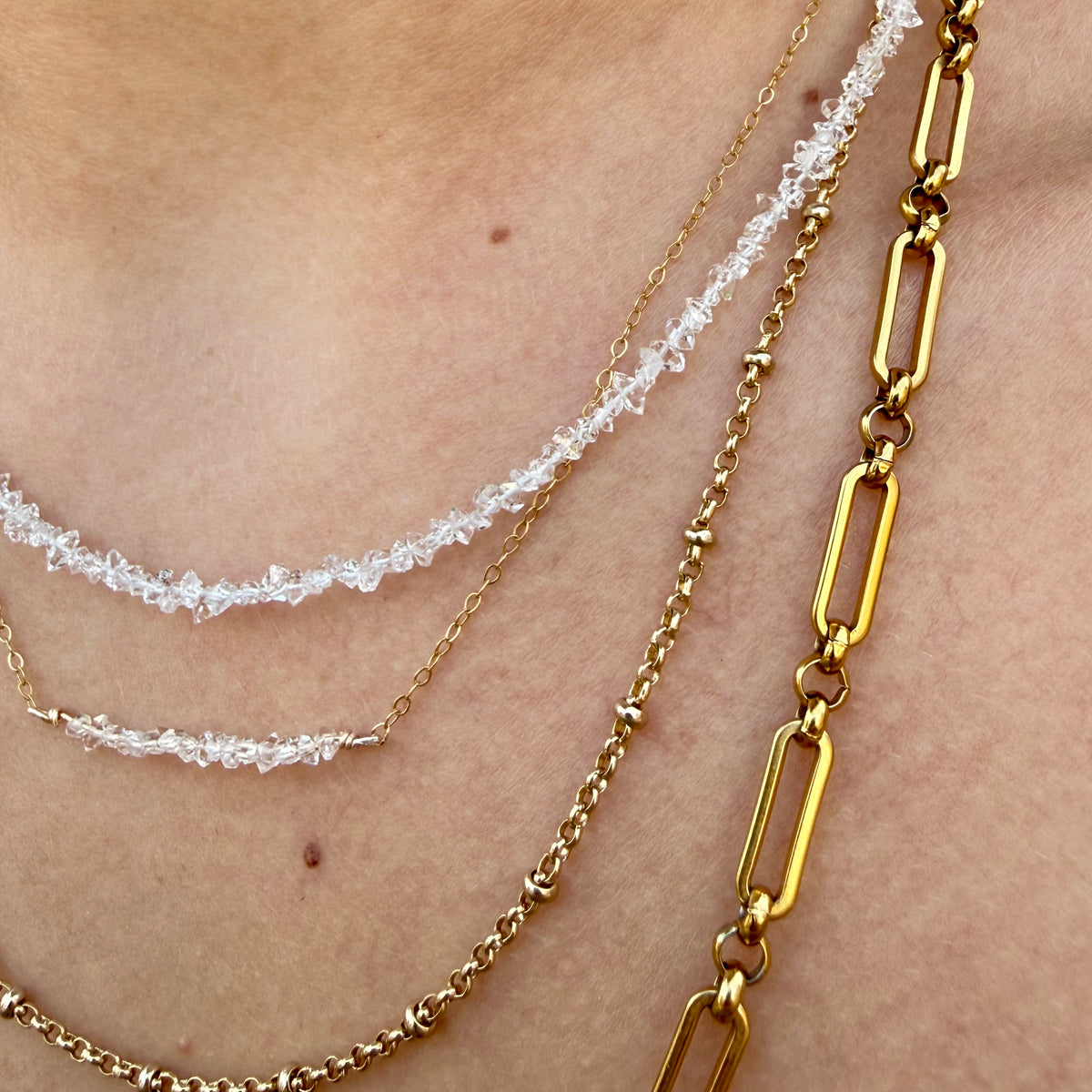 Two gold chains on a person's neck with a close-up view.