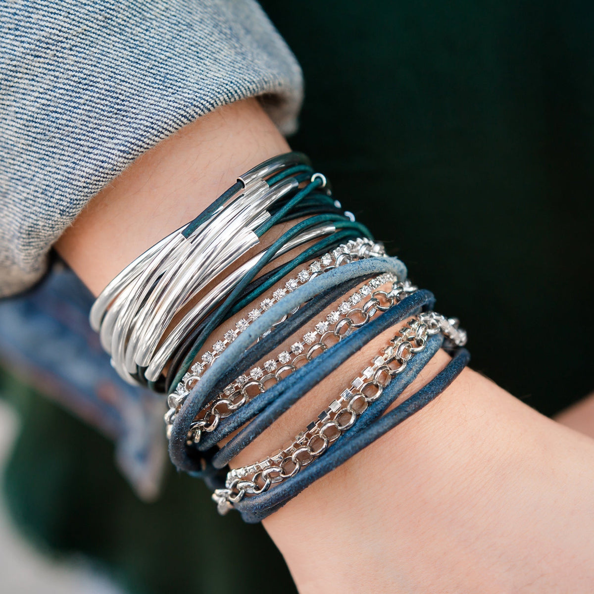 Natural Peacock leather Lizzy Classic bracelet layered with coordinating silver jewelry.