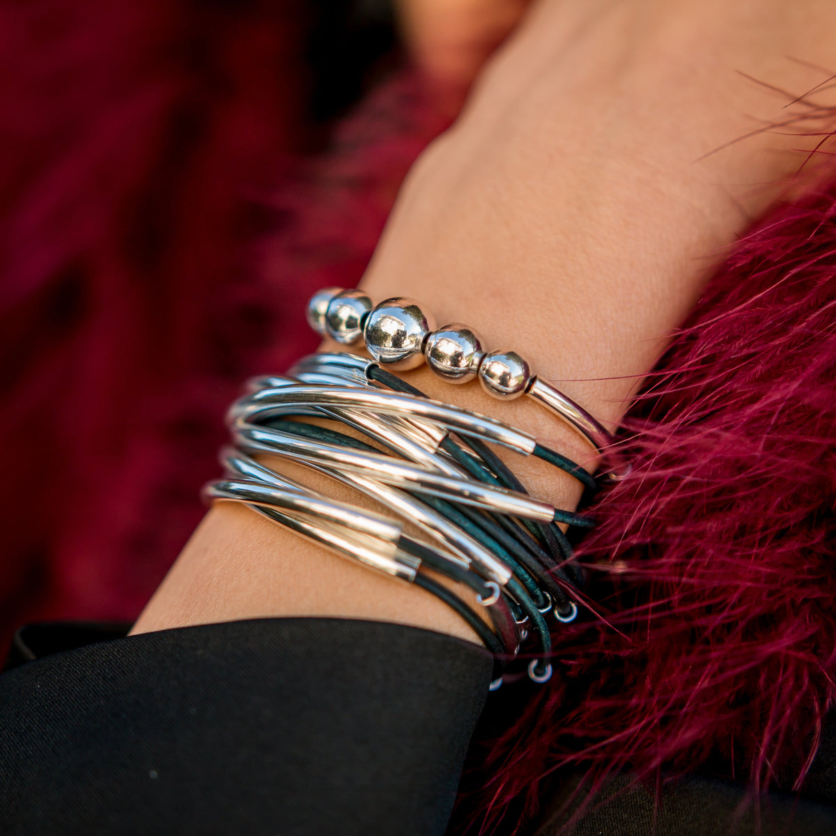 Woman wearing the Lizzy Classic 4-strand Natural Peacock leather wrap bracelet with silver-plated accents.