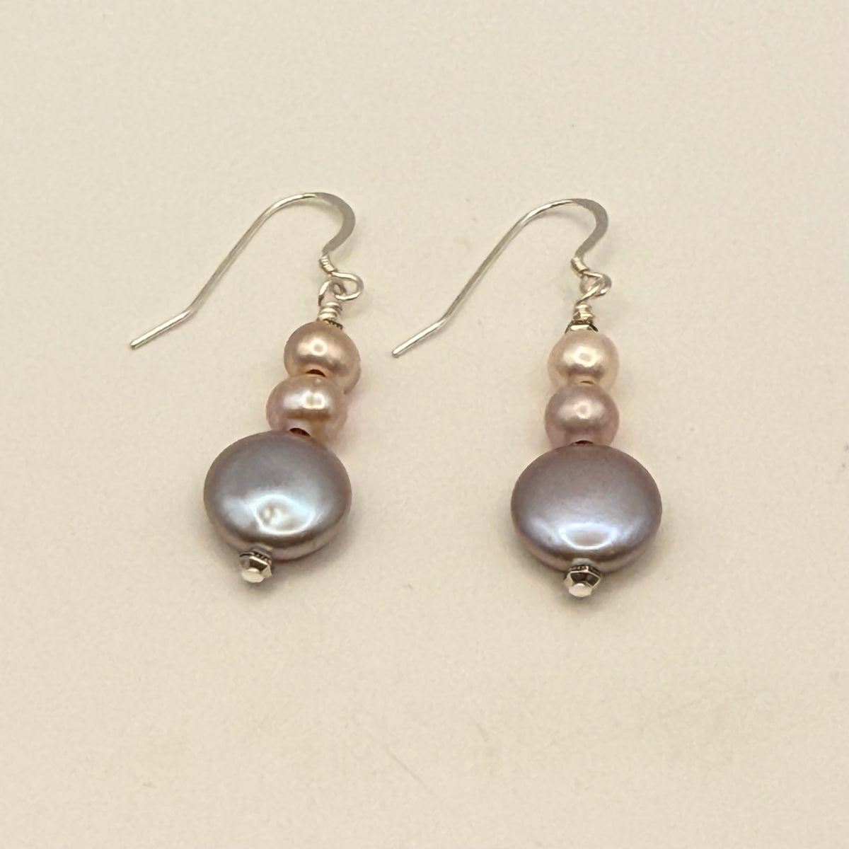 Pair of pearl earrings on a beige background