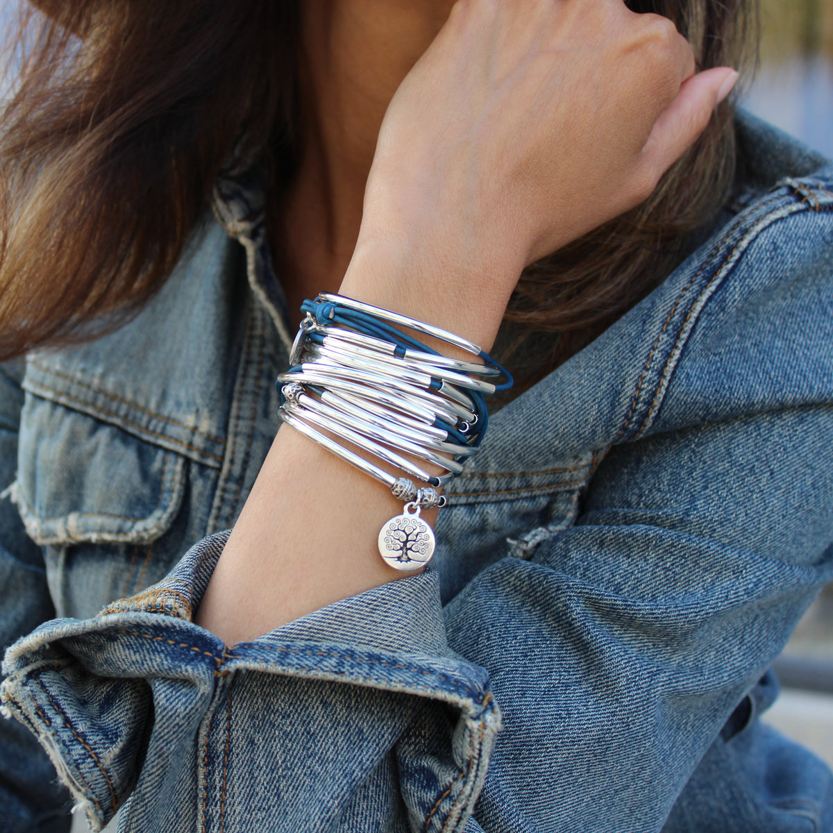 2 Leather wrap bracelets with silver crescents and accent beads. One has a tree of life charm attached.
