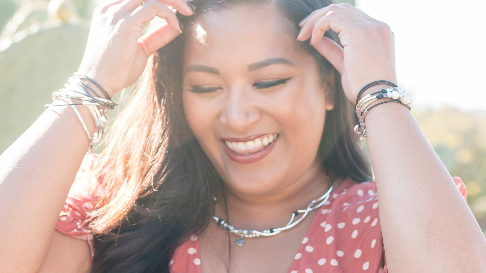 Woman in a red polka dot dress standing in front of cacti