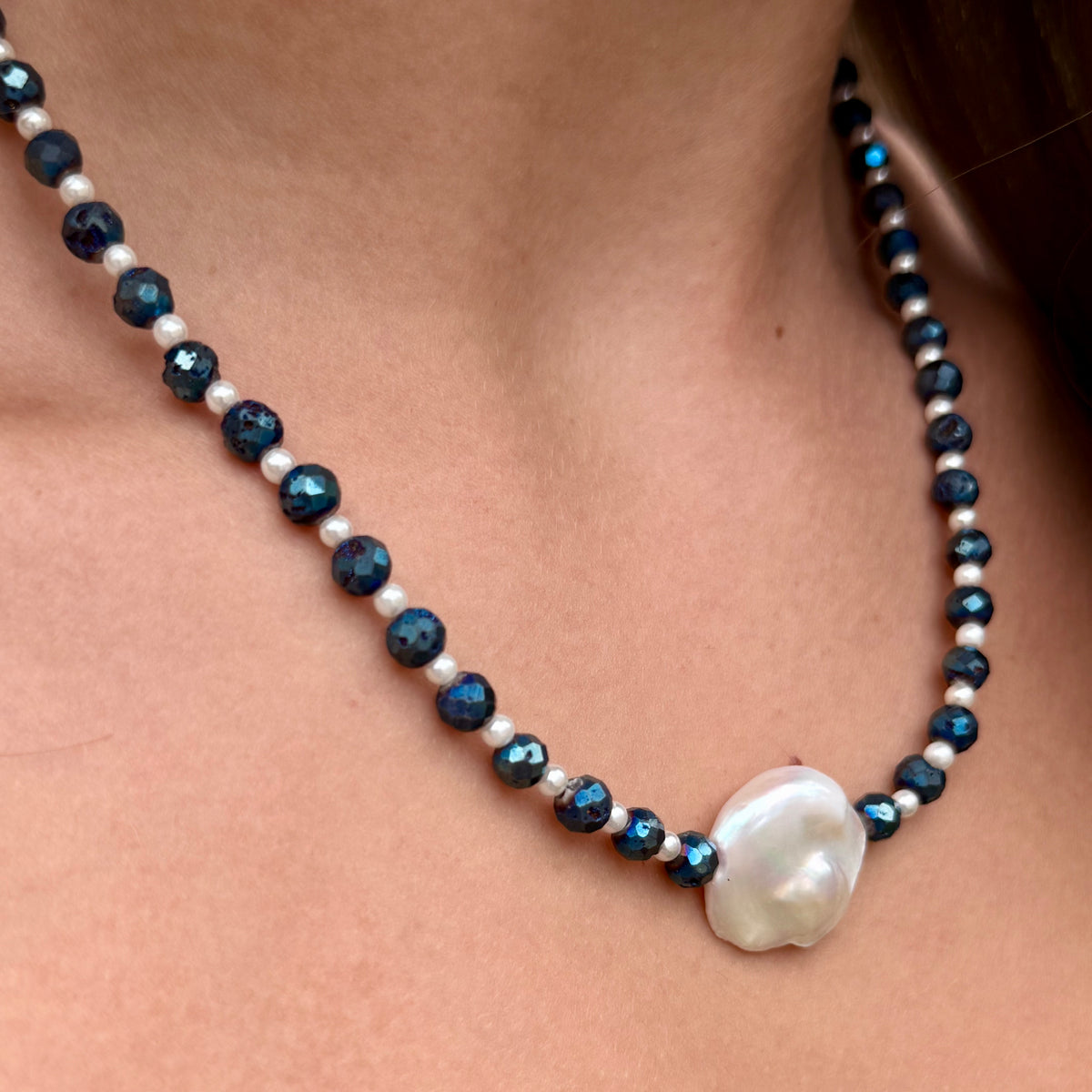 Necklace with blue and white beads on a person's neck